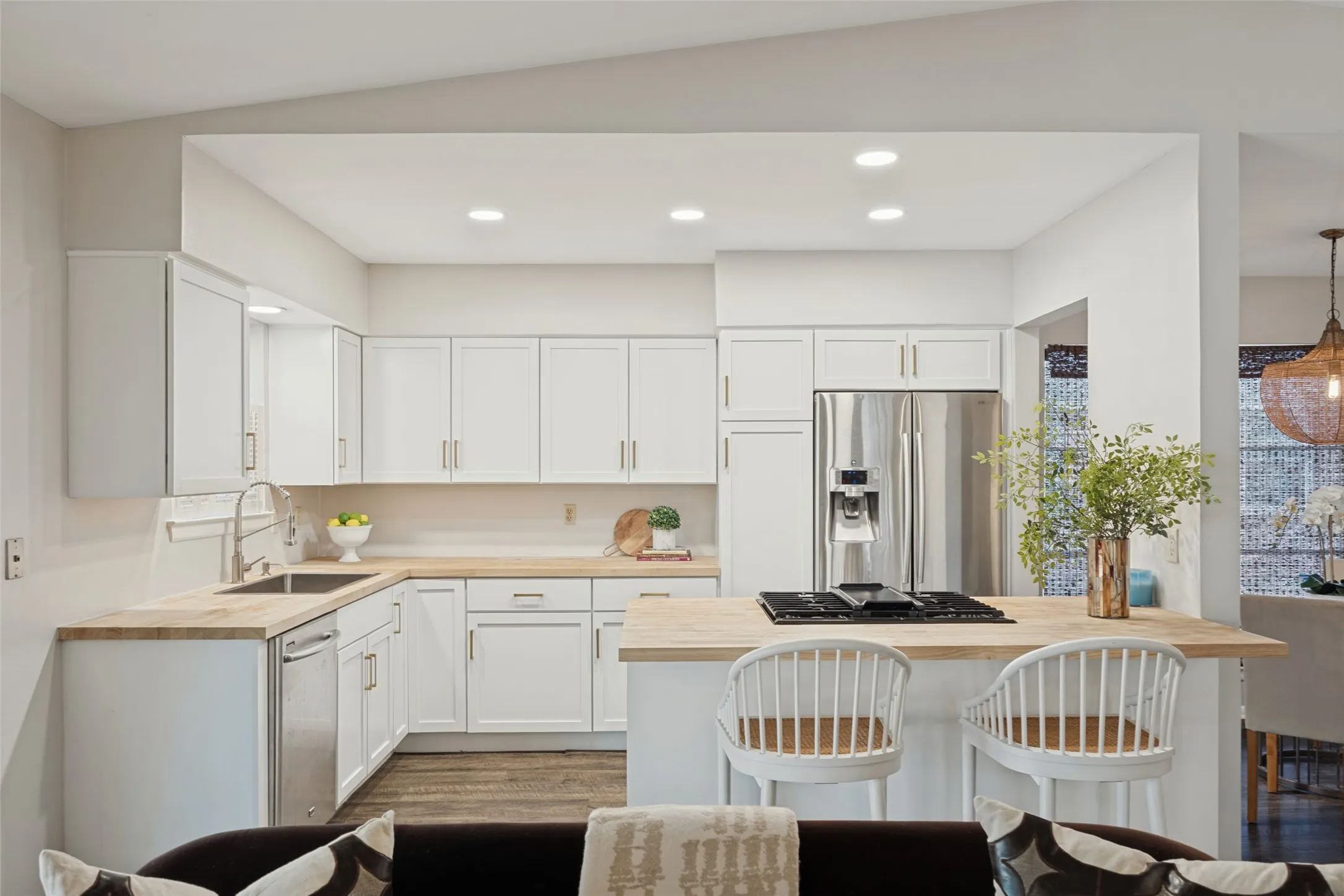 Kitchen featuring white cabinetry, light wood-finish countertops, stainless steel appliances, and recessed lighting