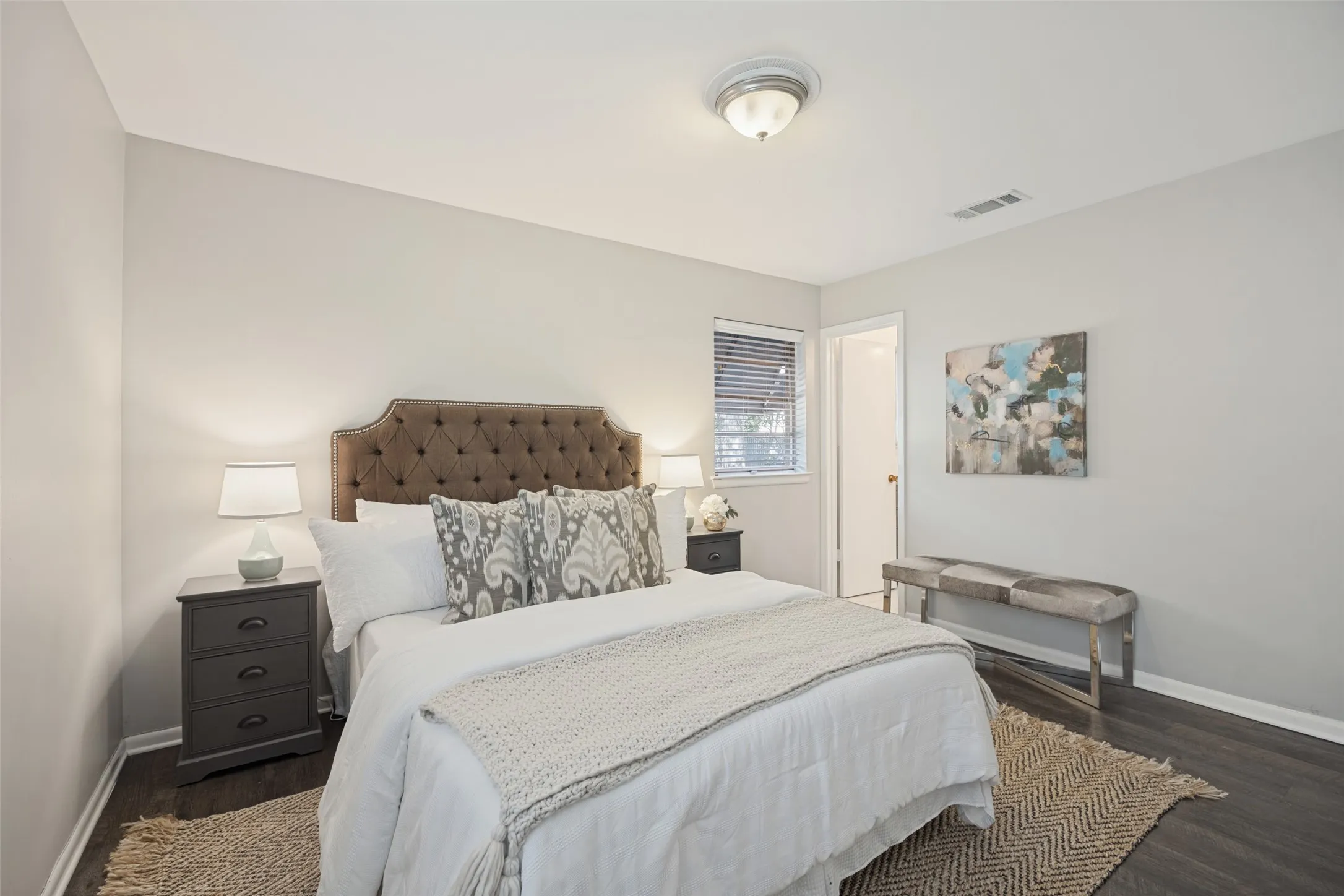 Wood-finish flooring, neutral wall tones, and a flush mount ceiling light fixture
