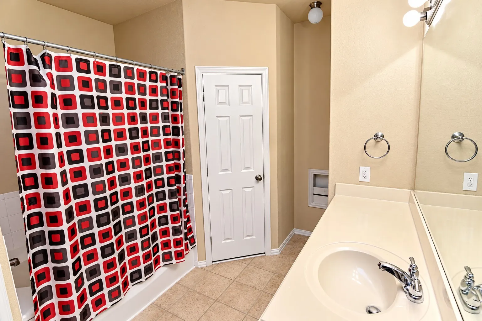 Bathroom featuring a single vanity with an integrated sink, polished chrome faucet, and a large wall-mounted mirror