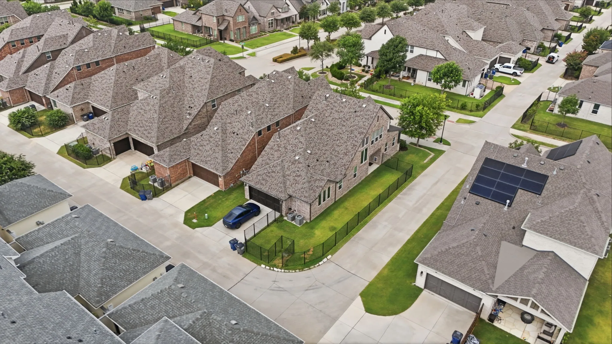 Residential neighborhood with a mix of brick and siding exteriors, shingle roofs, and concrete driveways