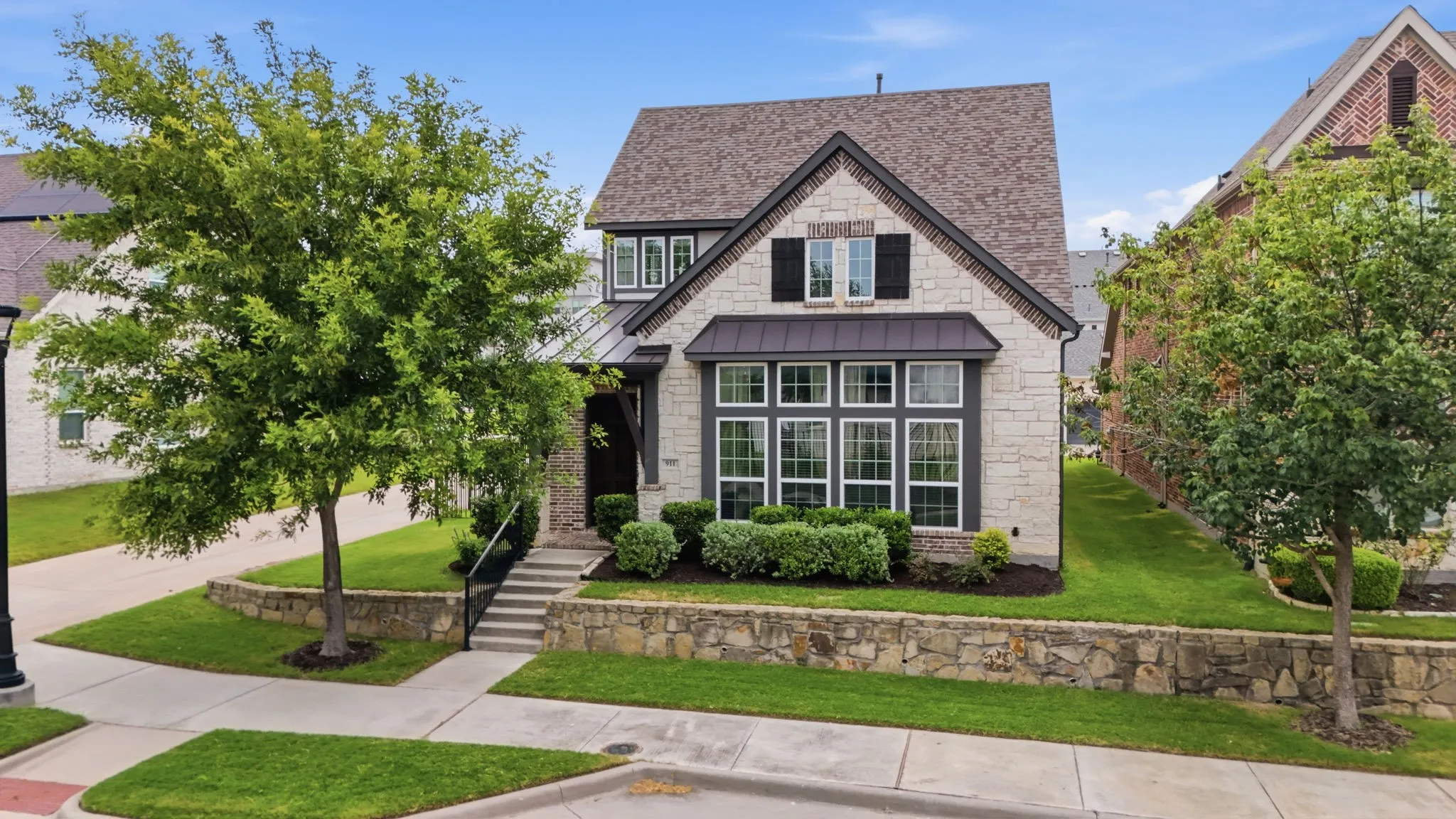 Stone and siding exterior with a dark shingle roof