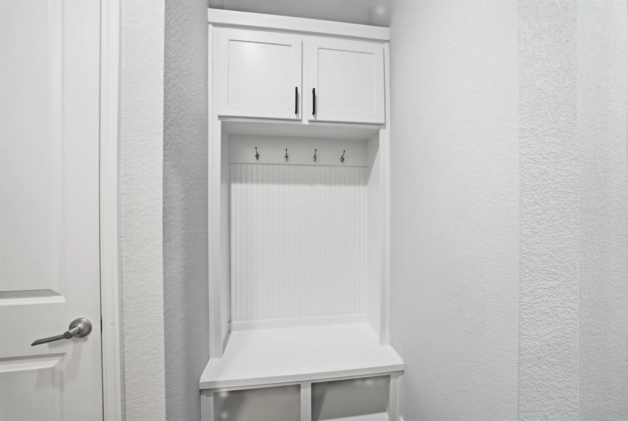 Built-in white cabinetry featuring shaker-style doors and dark hardware