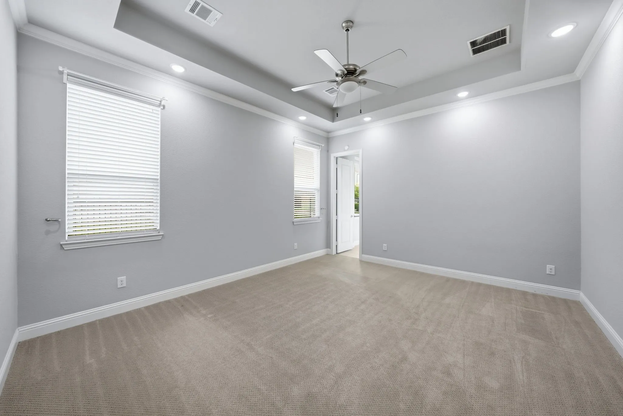 Tray ceiling featuring a ceiling fan, recessed lighting, and crown molding