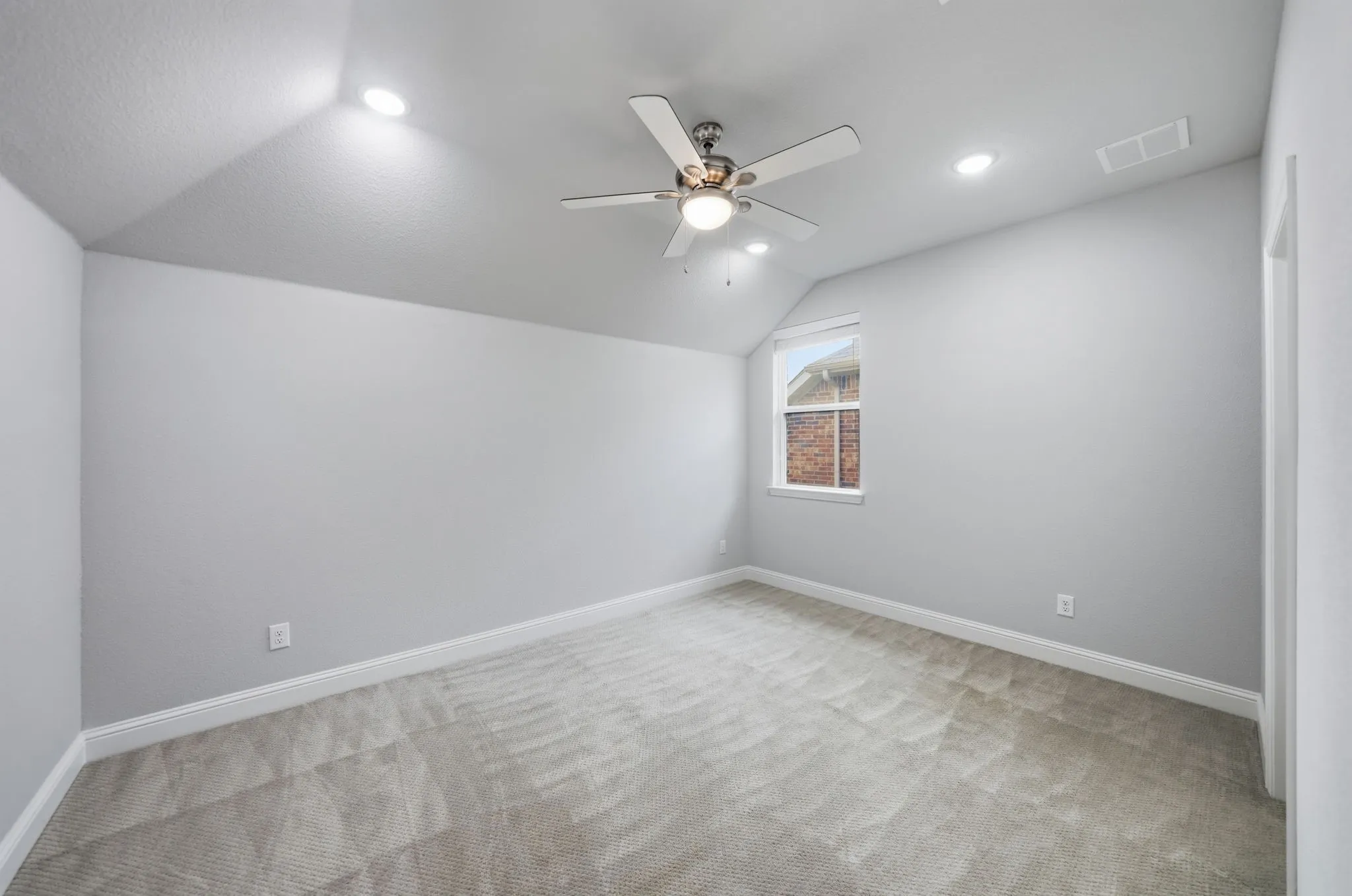 Sloped ceiling with recessed lighting, ceiling fan, and carpet flooring