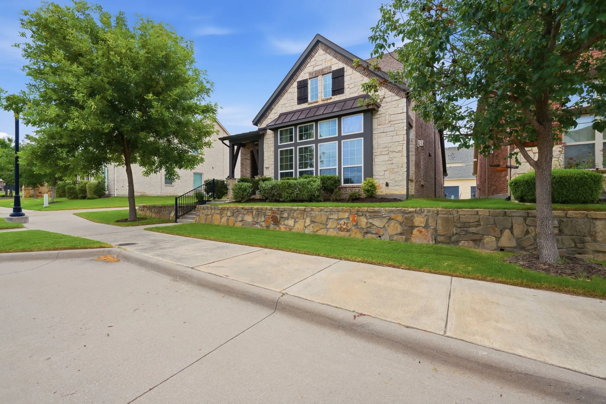 Stone facade with dark trim accents, featuring a prominent bay window