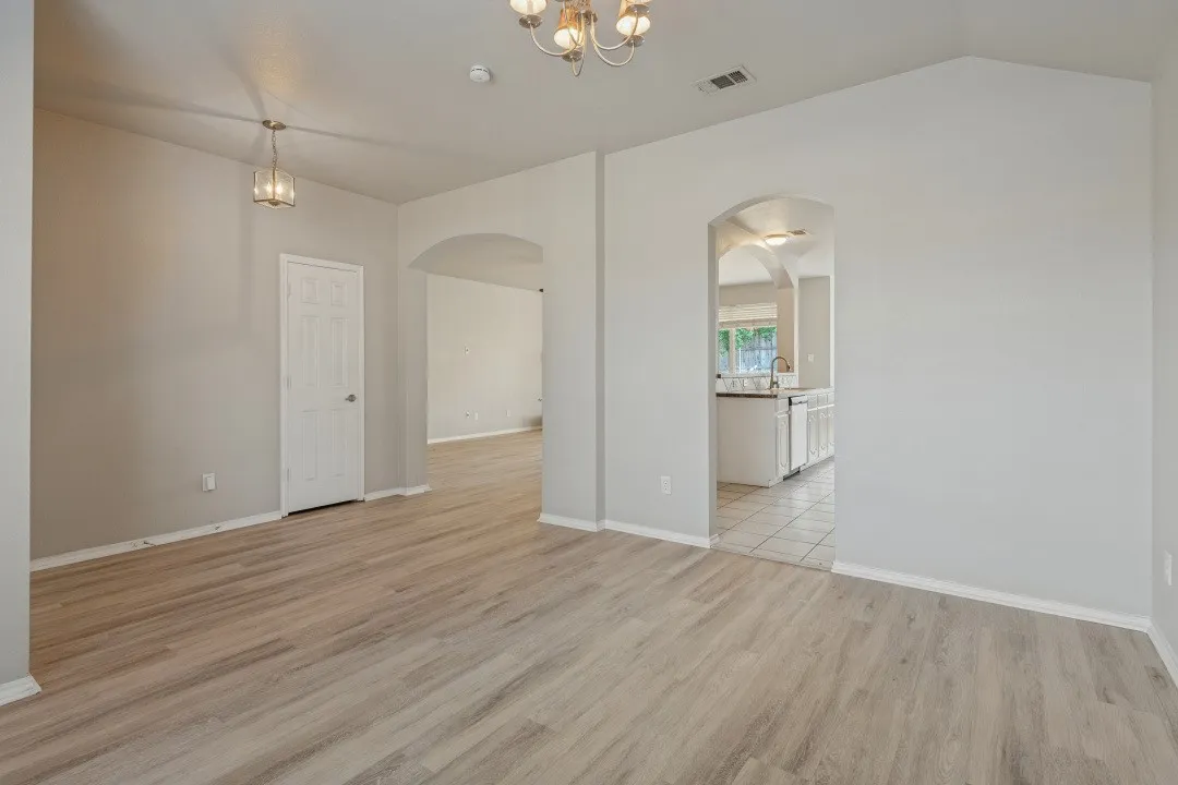 Wood-finish flooring throughout, vaulted ceiling, and arched doorways