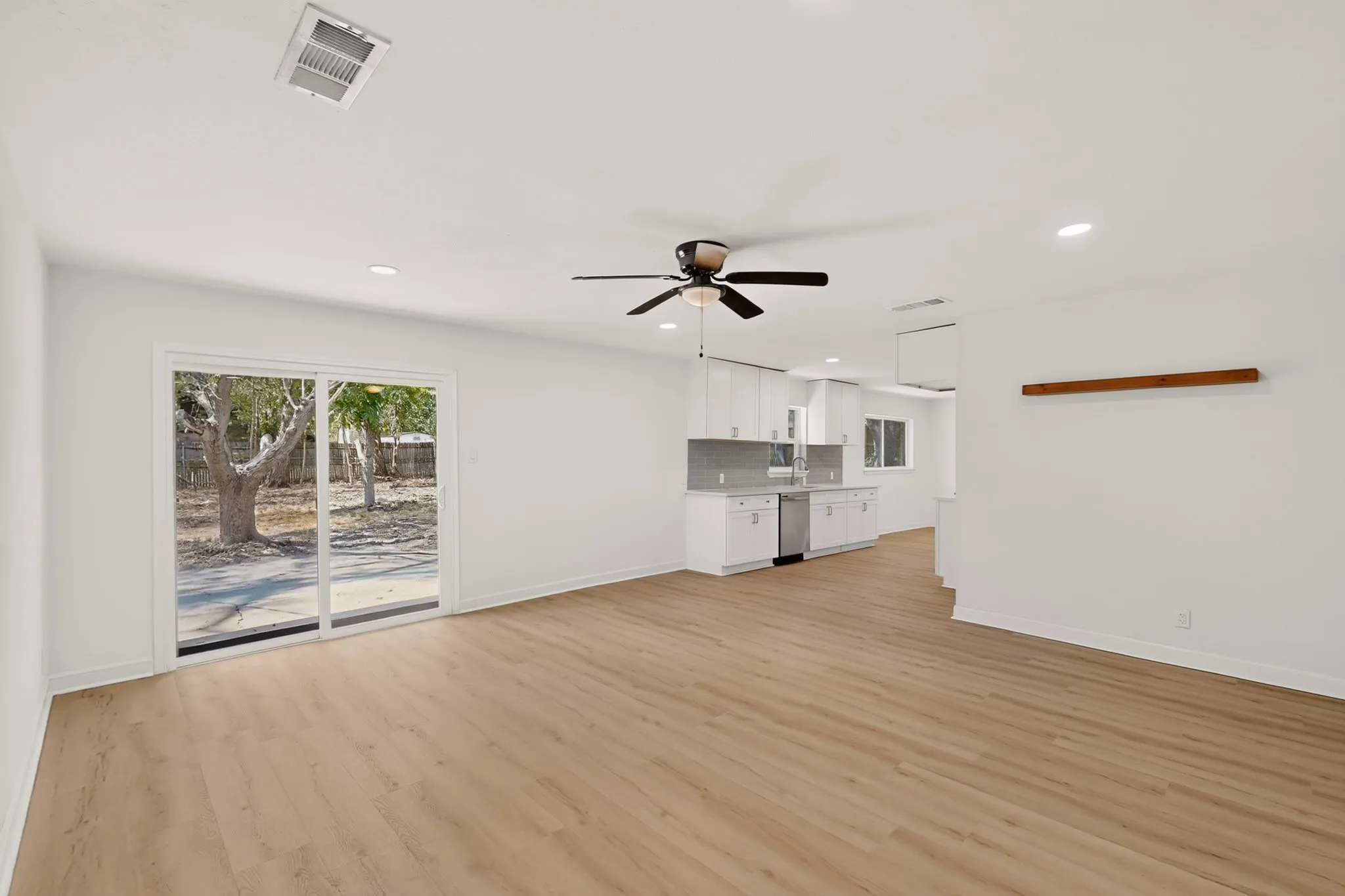 Open-concept living area featuring wood-finish flooring, recessed lighting, and a ceiling fan