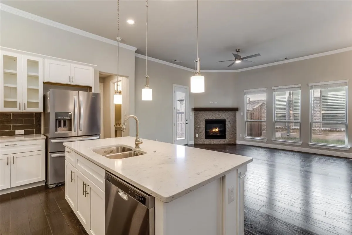 Kitchen island with integrated sink, white cabinetry, and stainless steel appliances