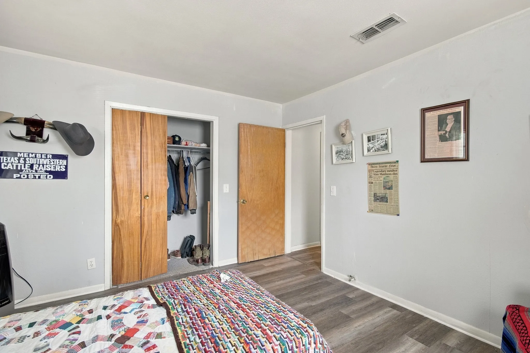 Wood-finish flooring with light gray walls, featuring a bi-fold closet with wood doors