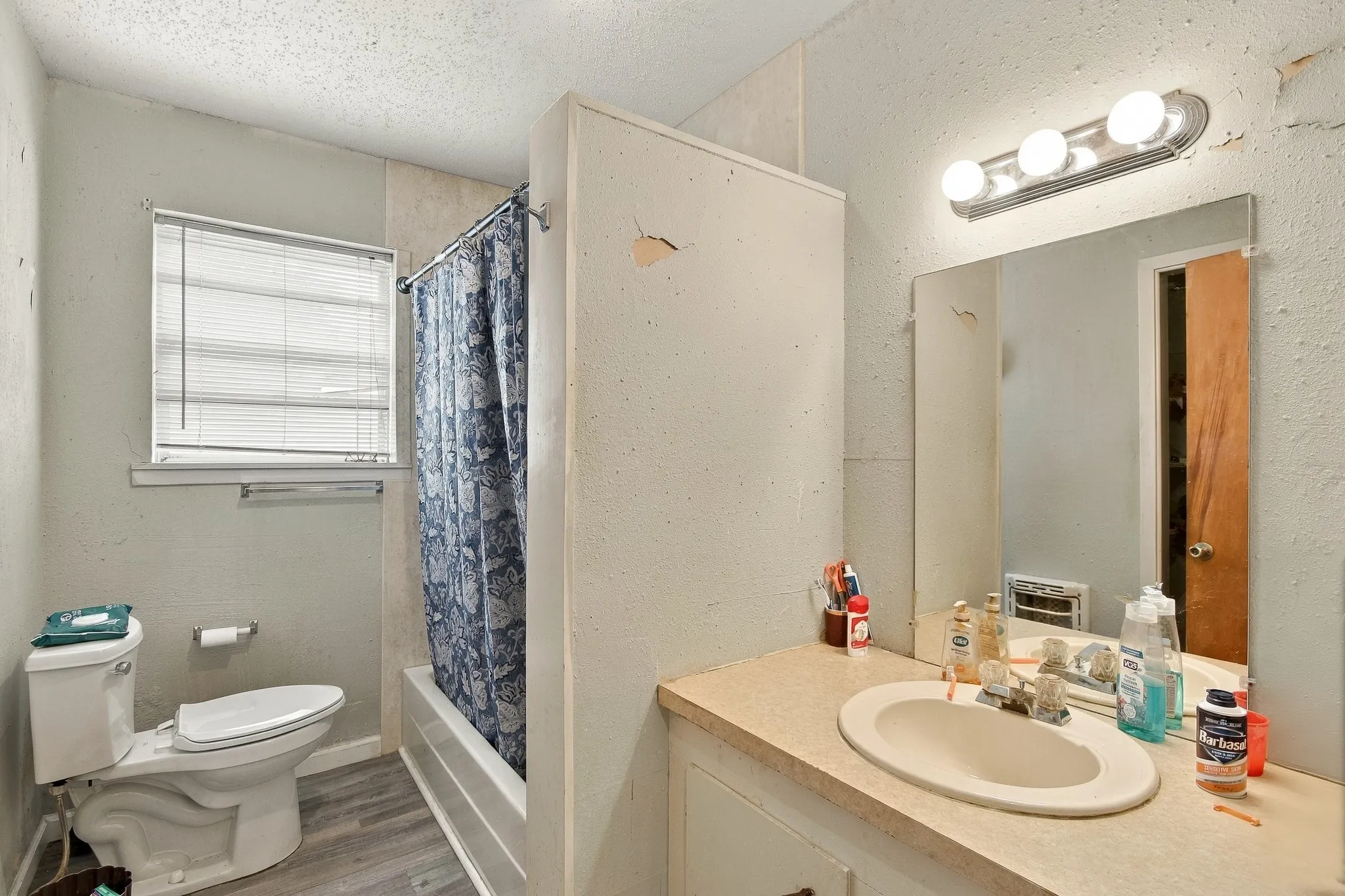 Built-in vanity with an oval sink, laminate countertop, and wall-mounted mirror