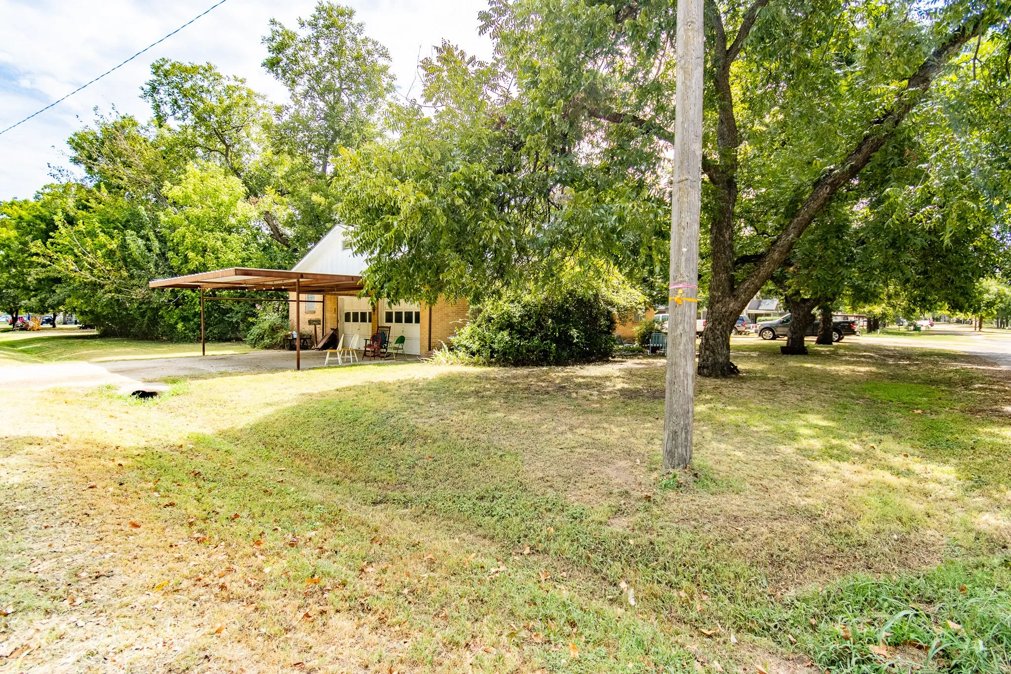 Detached structure featuring a carport, two garage doors, and a covered porch area