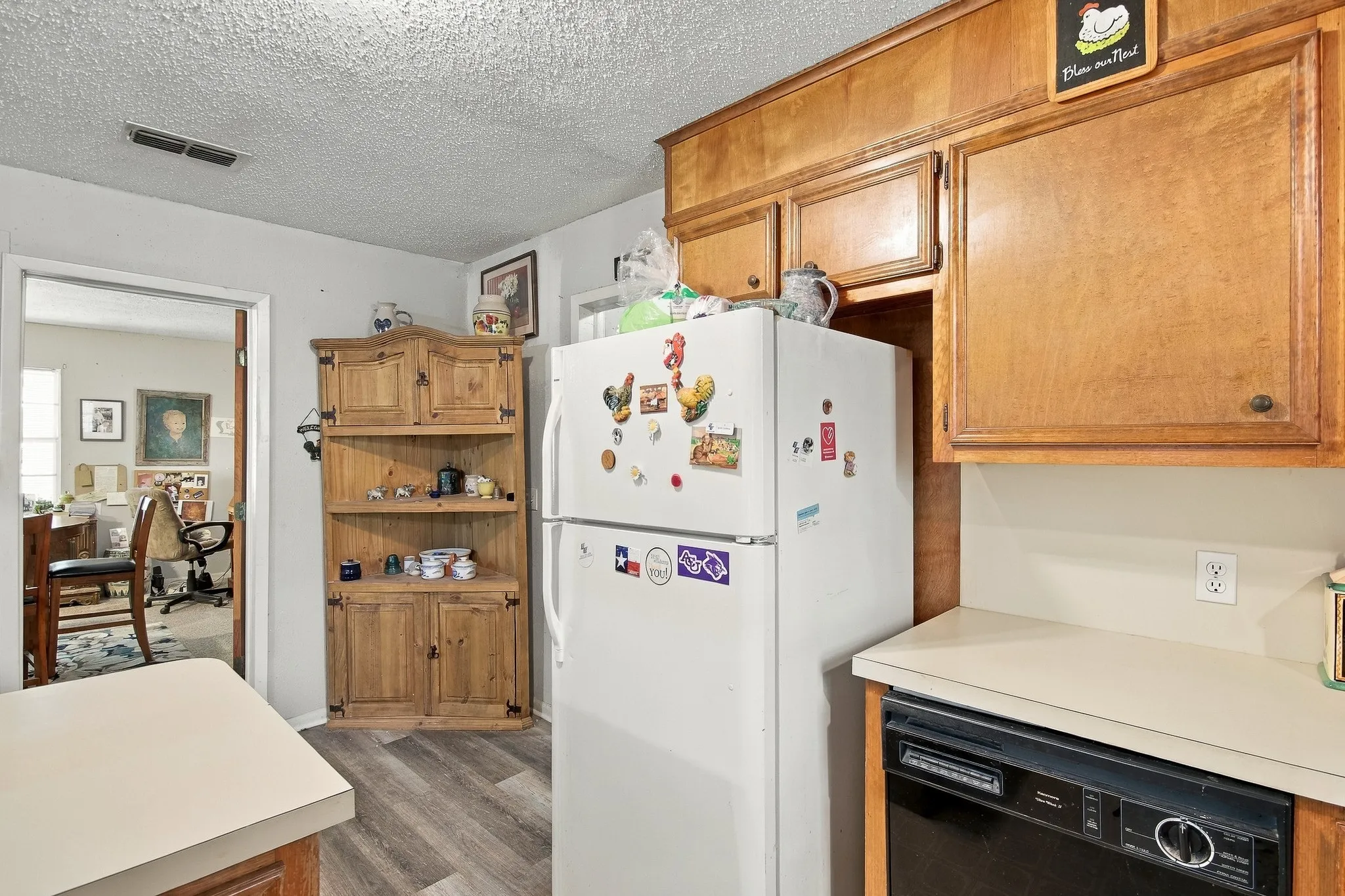 Kitchen featuring wood-finish cabinetry, solid surface countertops, and wood-finish flooring