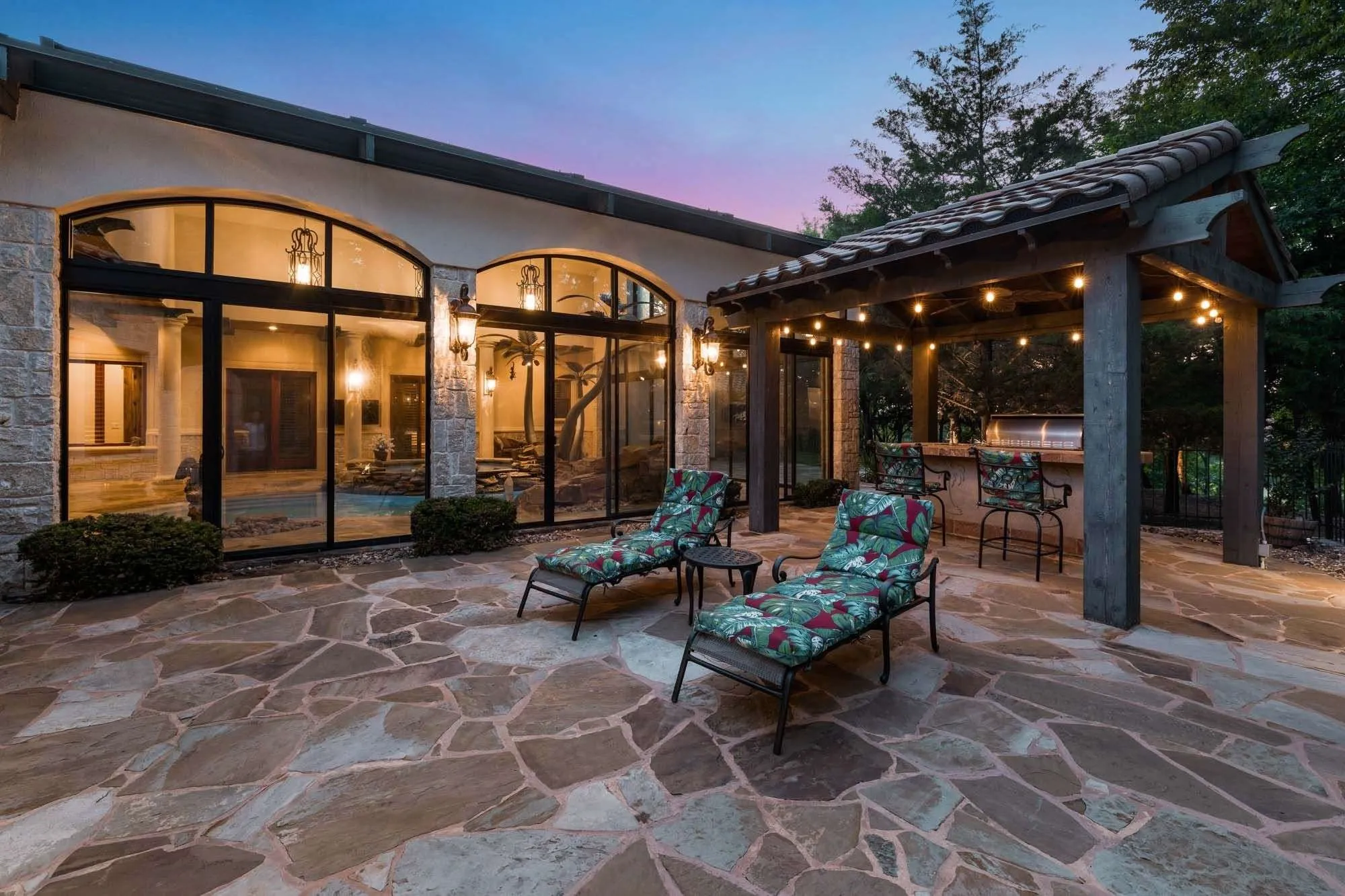 Patio boasts covered grilling area near the pool