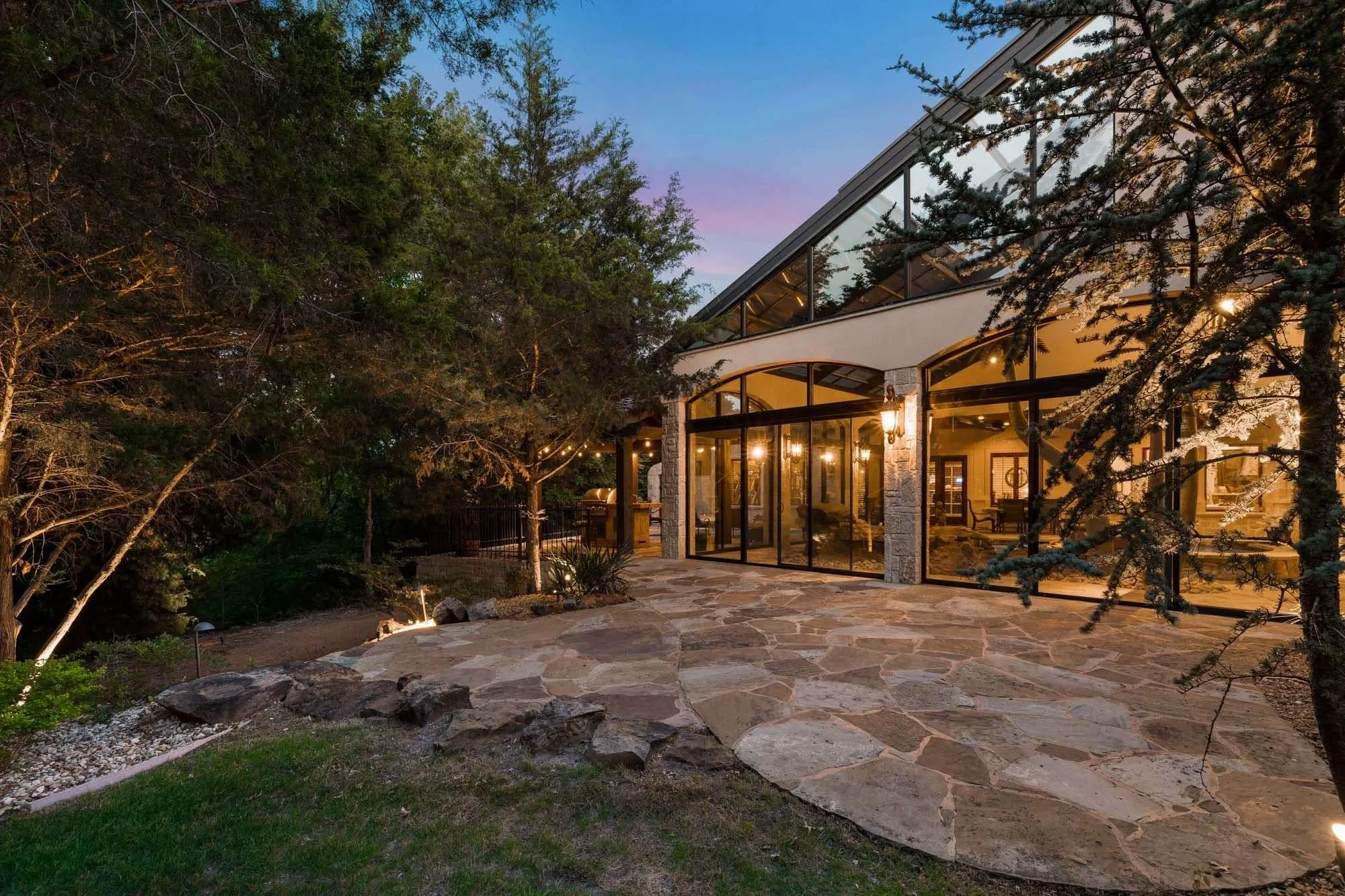 Stone patio near pool with staircase down to the barn
