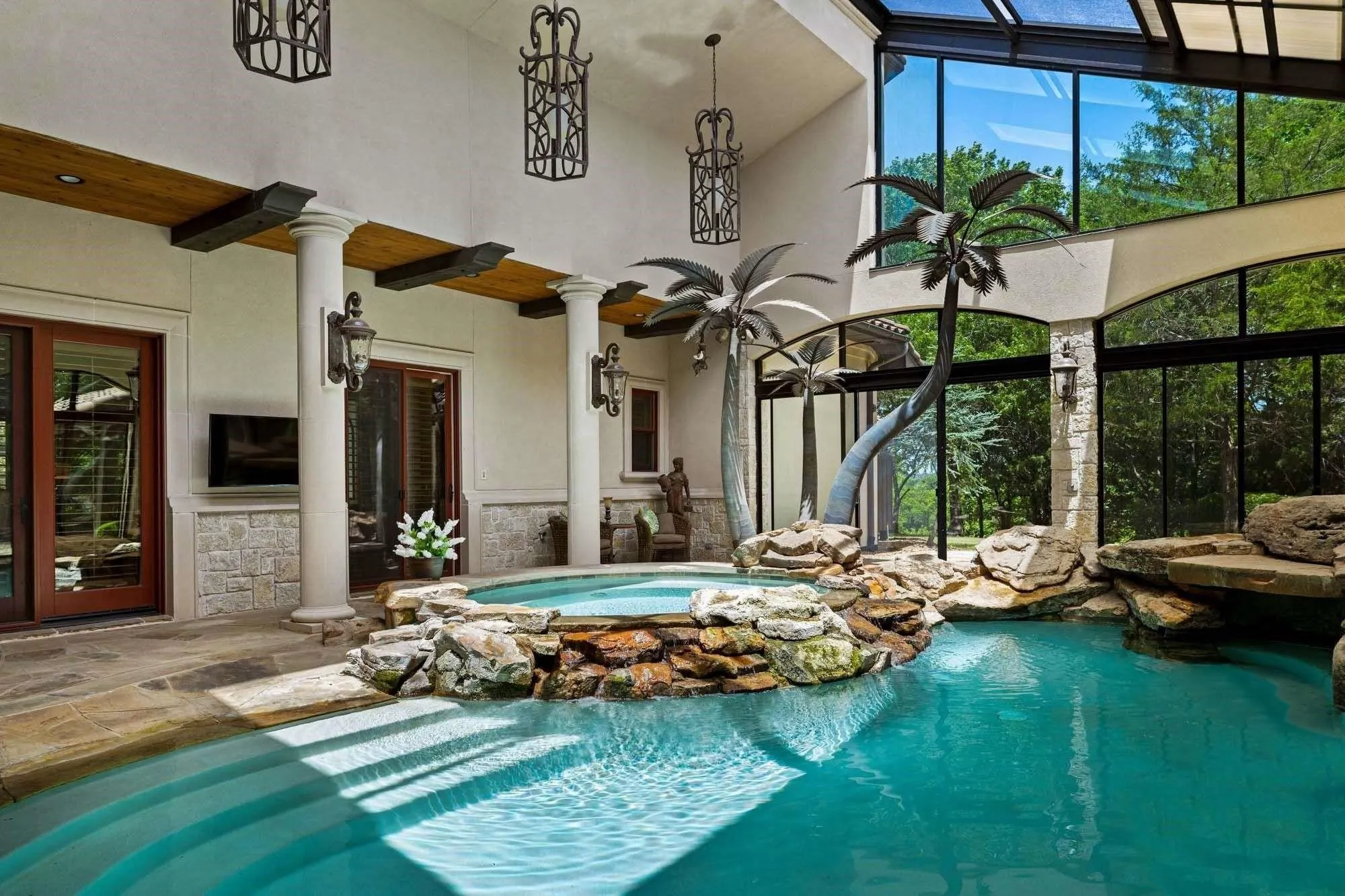 Sliding glass doors with screens surround the pool to allow airflow while keeping the bugs out