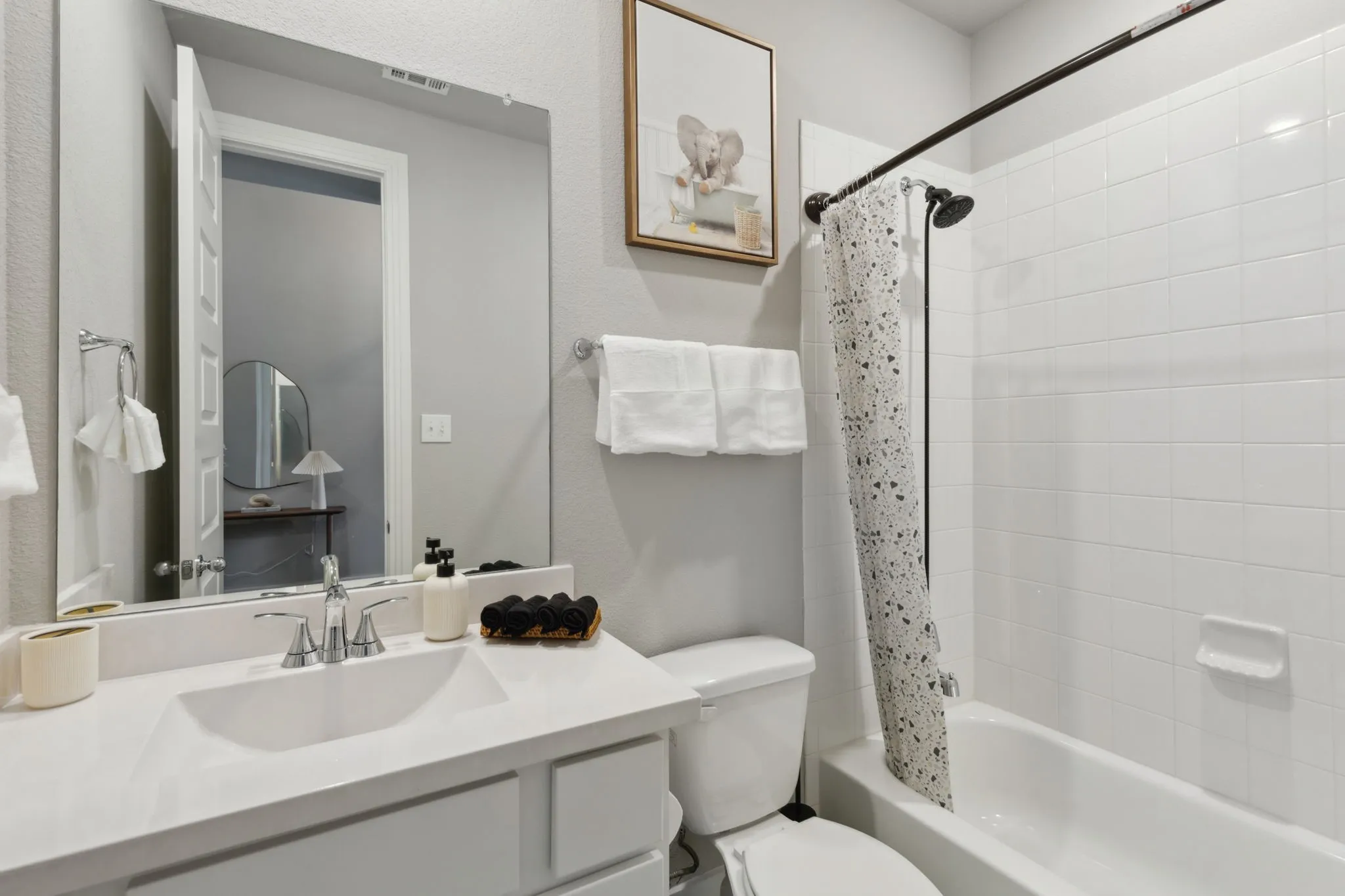 White vanity with an integrated rectangular sink, chrome-finish faucet, and a large wall-mounted mirror