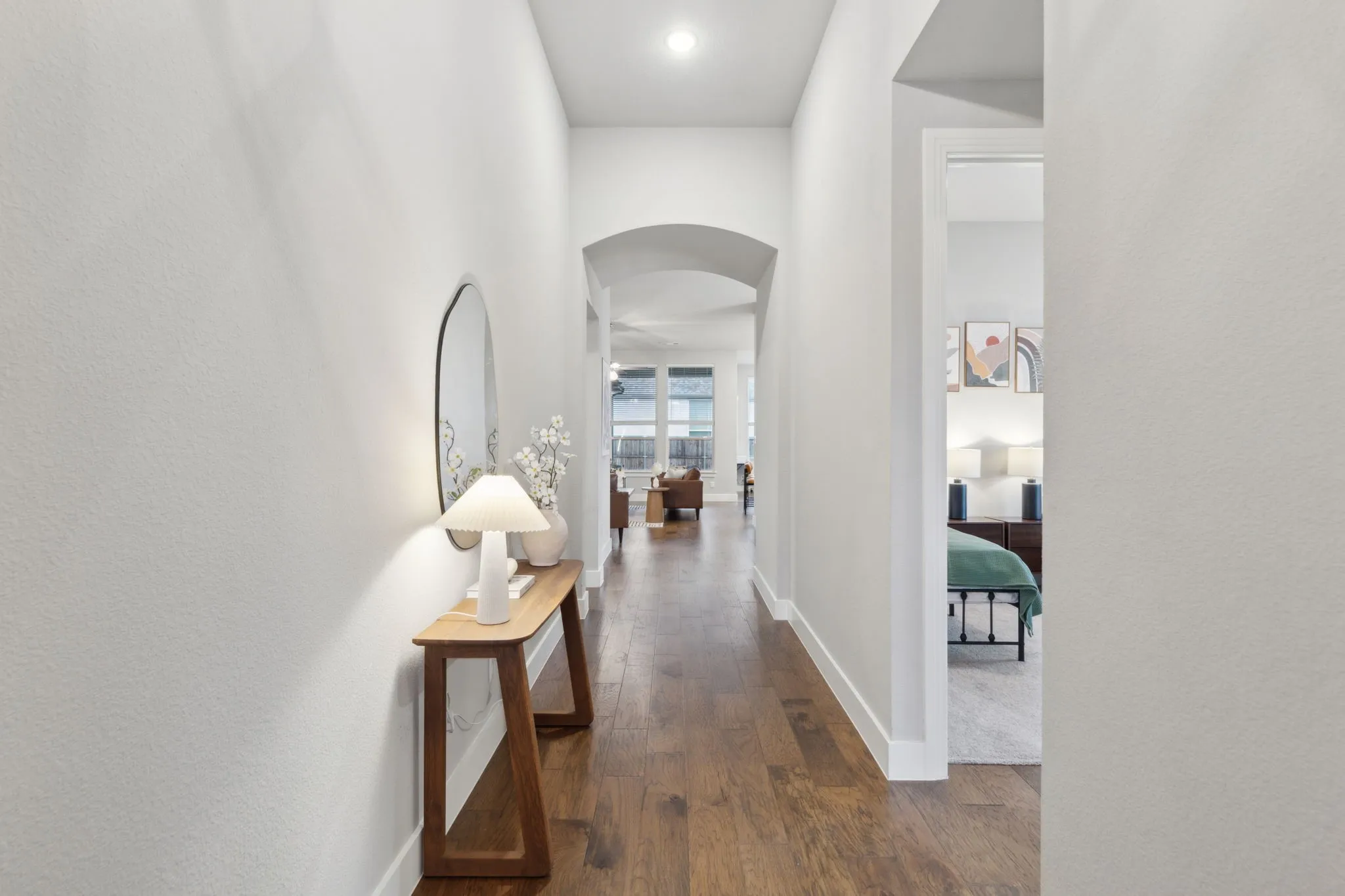 Wood-finish flooring, white walls, and an arched doorway