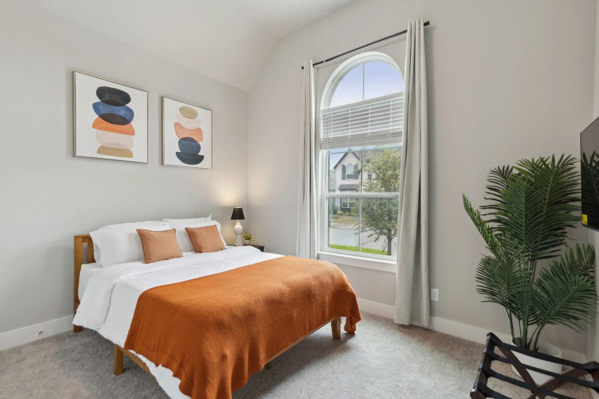 Arched window with blinds, light gray walls, and carpet flooring