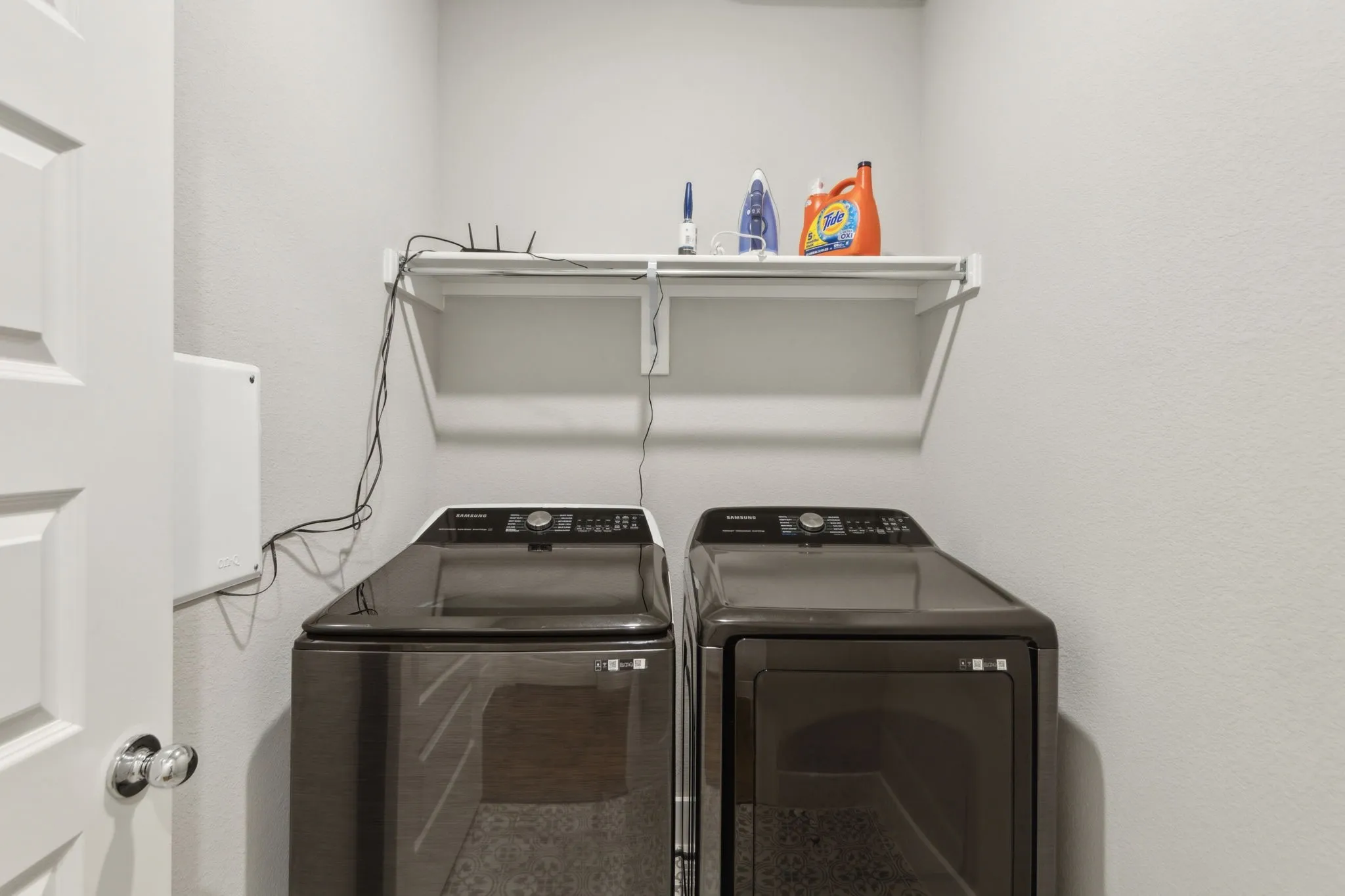 Laundry area featuring a wall-mounted shelf