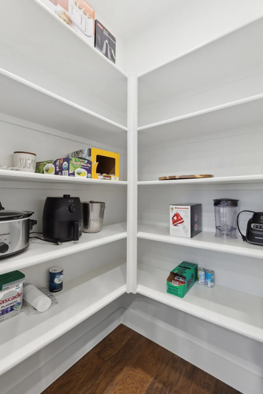 Built-in shelving, white finish, wood-finish flooring, ample storage capacity, corner configuration