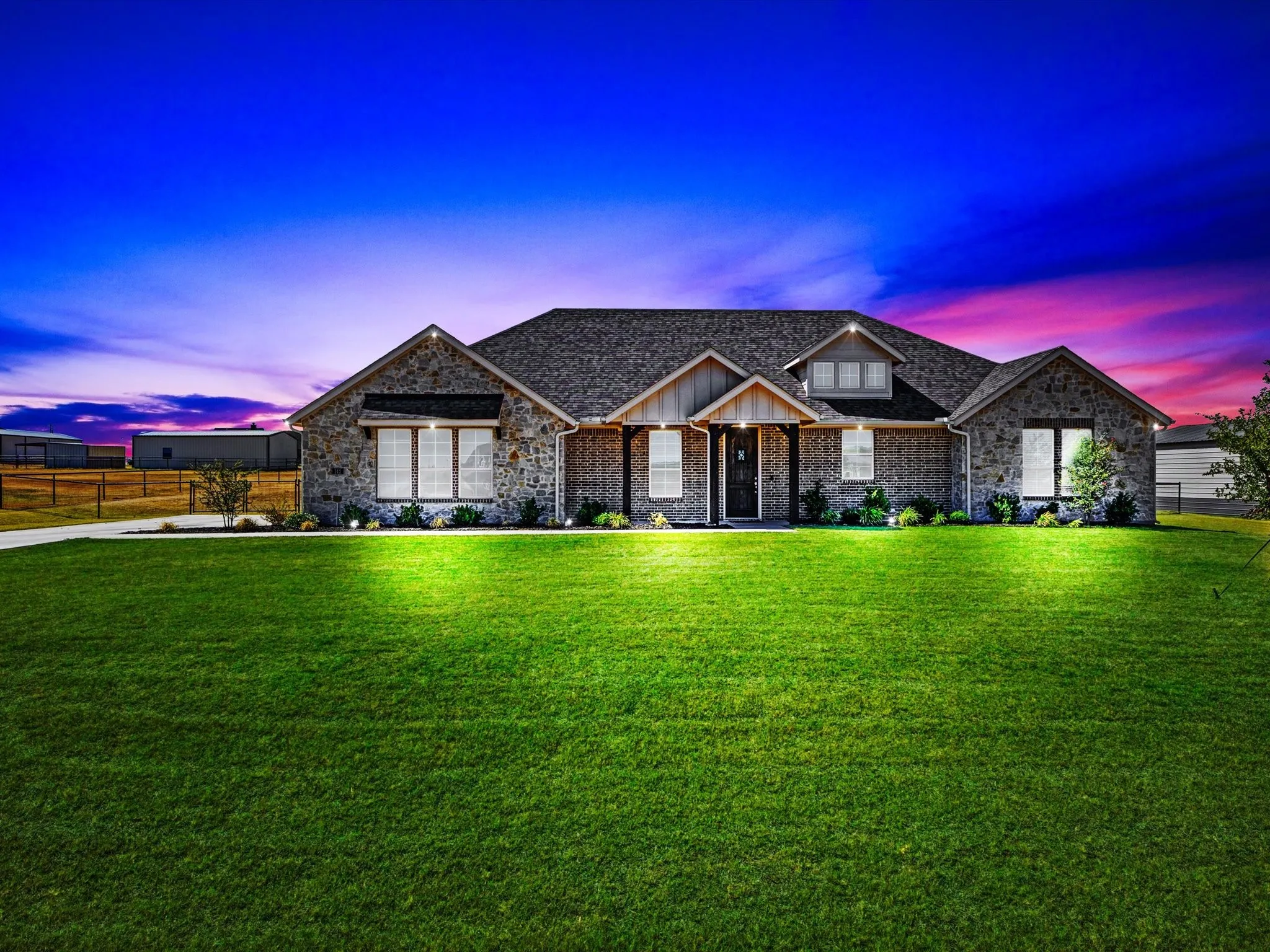 Stone and brick veneer exterior with a dark shingle roof