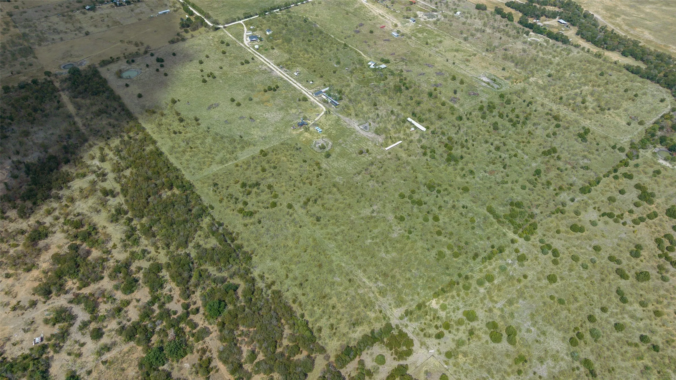 Expansive land parcel featuring natural vegetation and scattered trees