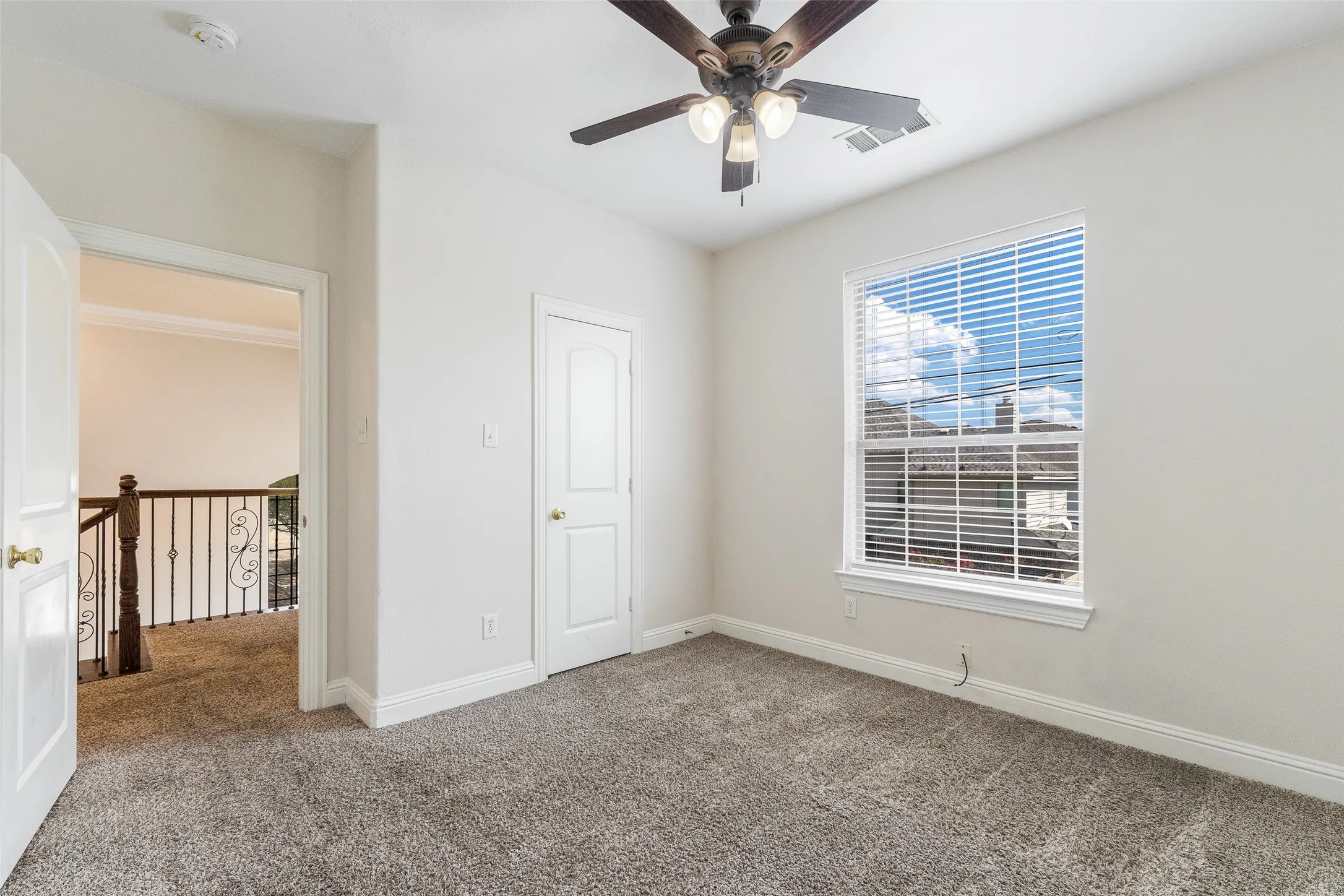 Plush carpet flooring, ceiling fan with integrated lighting, window with blinds, interior door, and a built-in closet