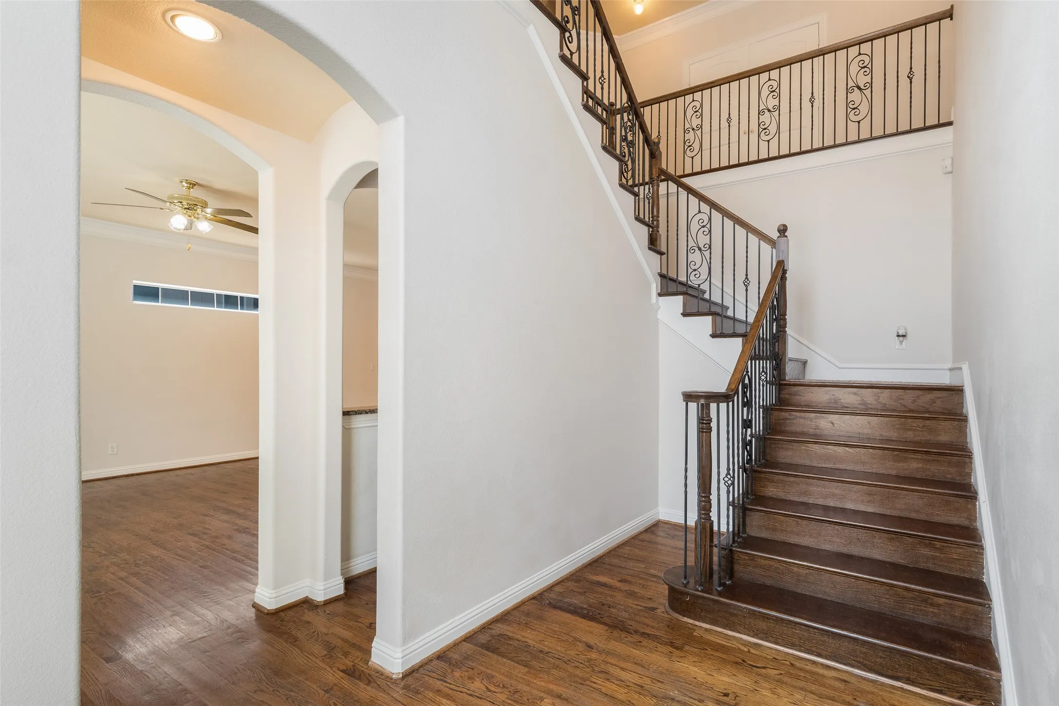 Hardwood flooring extends throughout the entryway and staircase