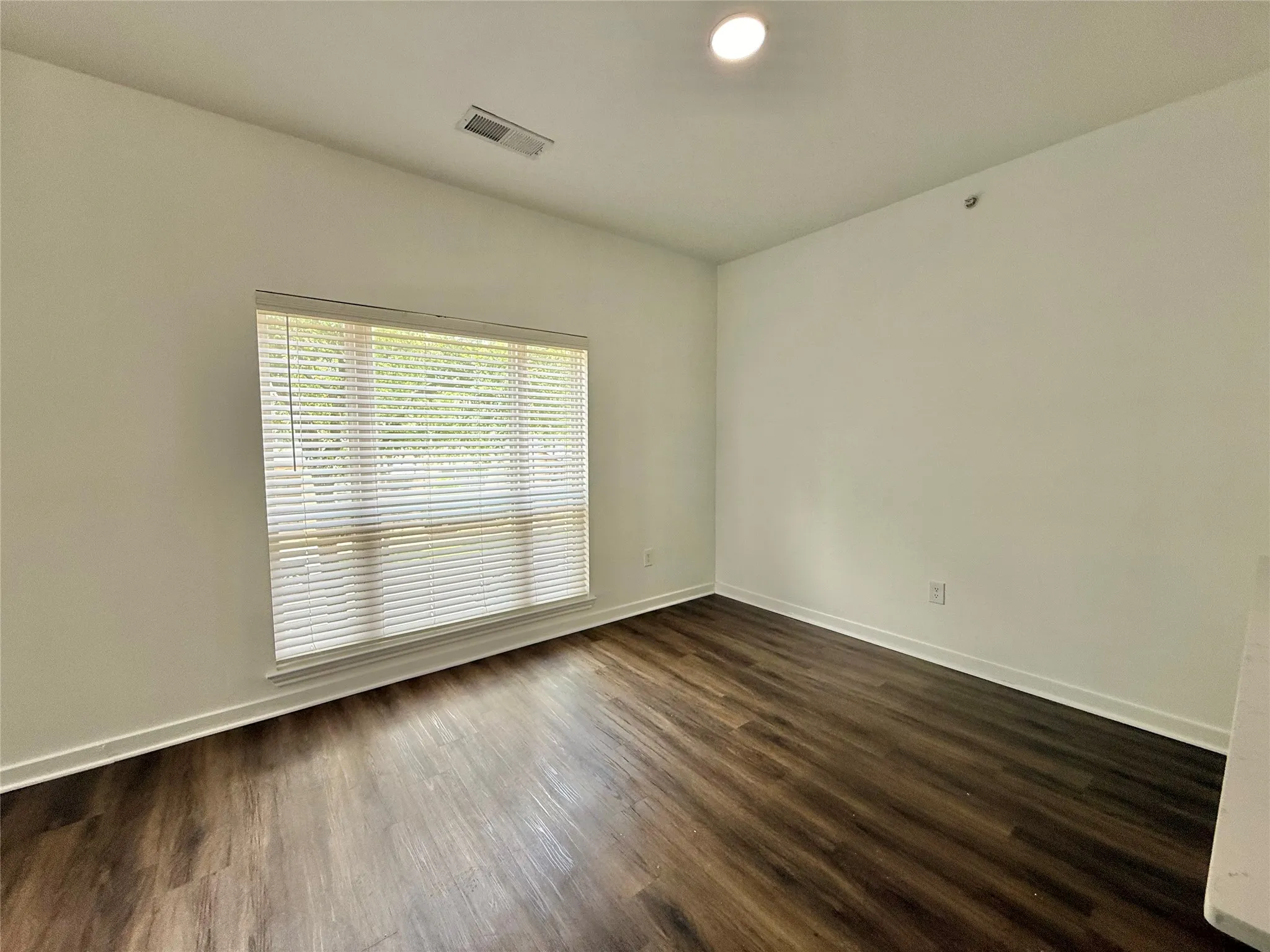 Unfurnished room featuring dark wood finished floors and baseboards