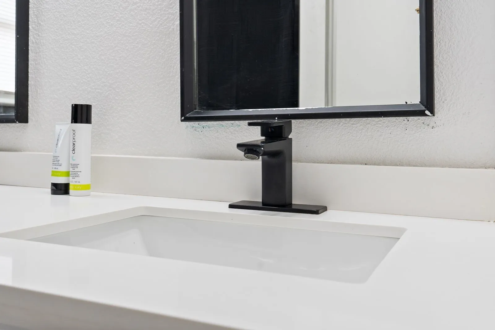 Integrated rectangular sink with a matte black faucet, set into a white countertop