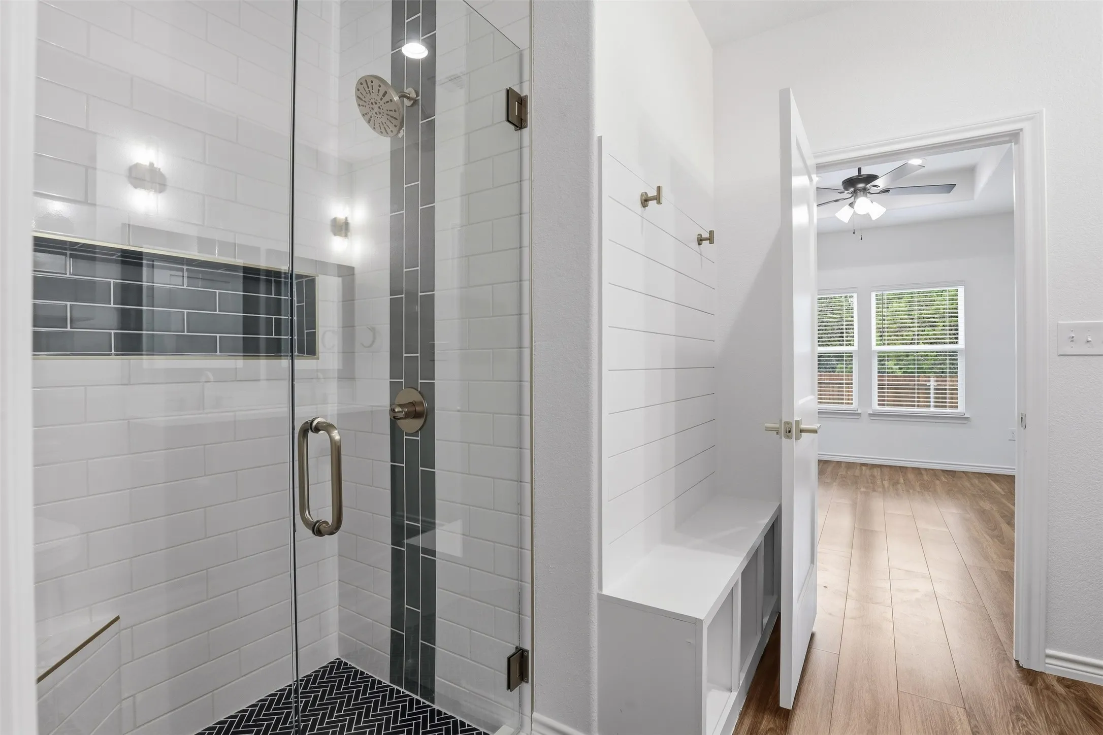 Large Primary Shower with Glass door and custom tile work on floor, waterfall tile, and large niche