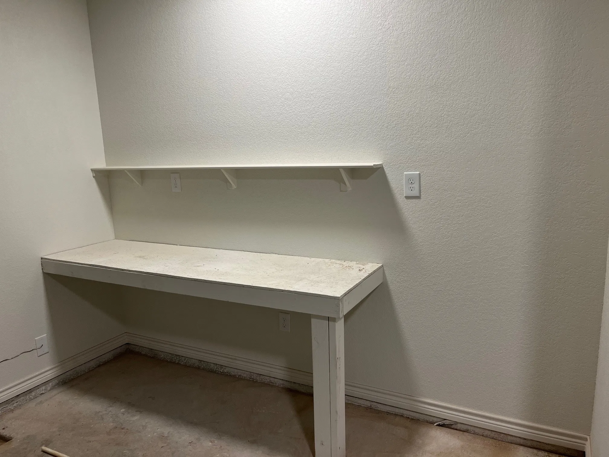 Work Bench in the garage with outlets, Lights and space for tool chest or extra fridge.