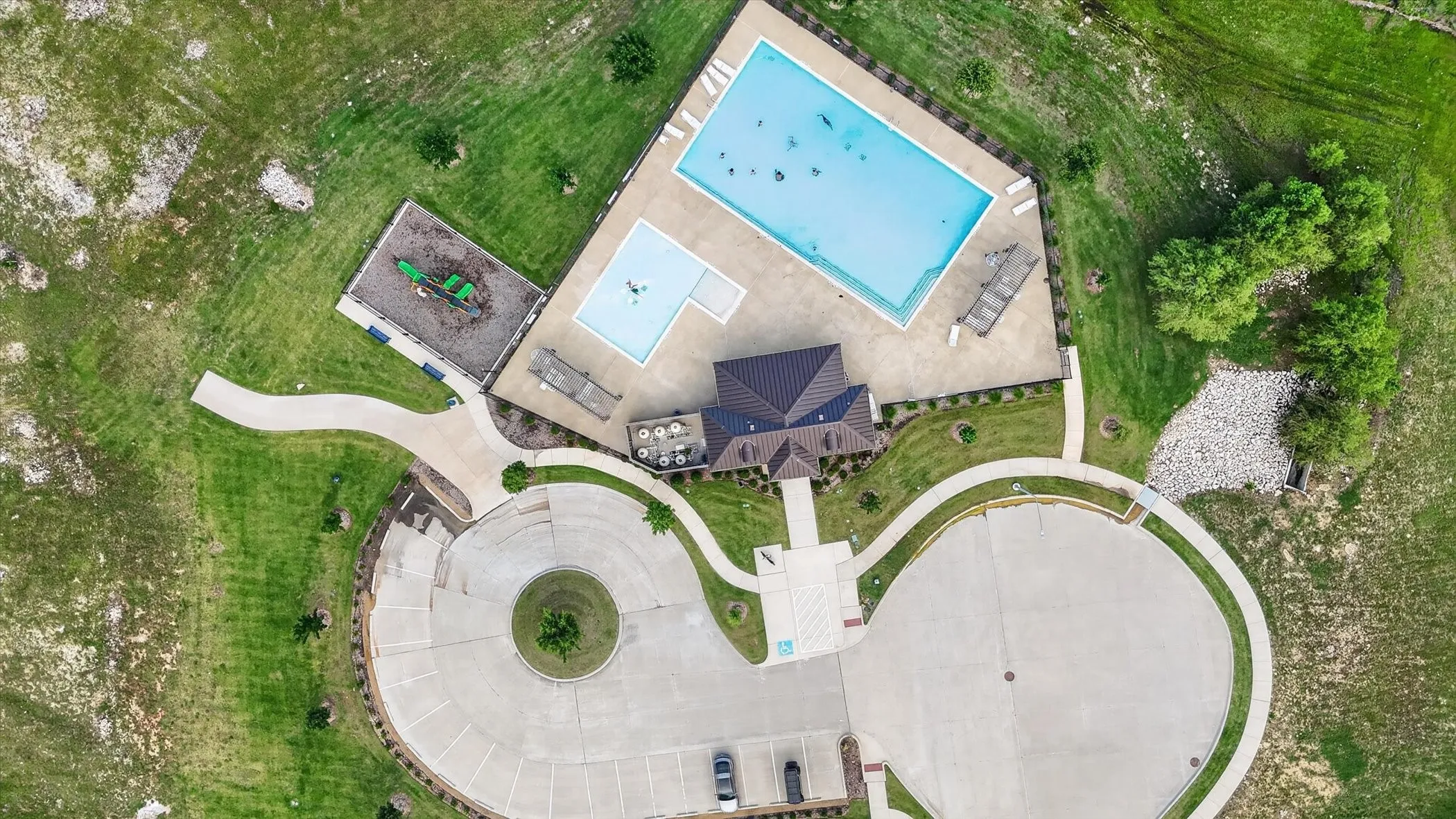 Community recreation area featuring a swimming pool, wading pool, playground, and paved walking paths