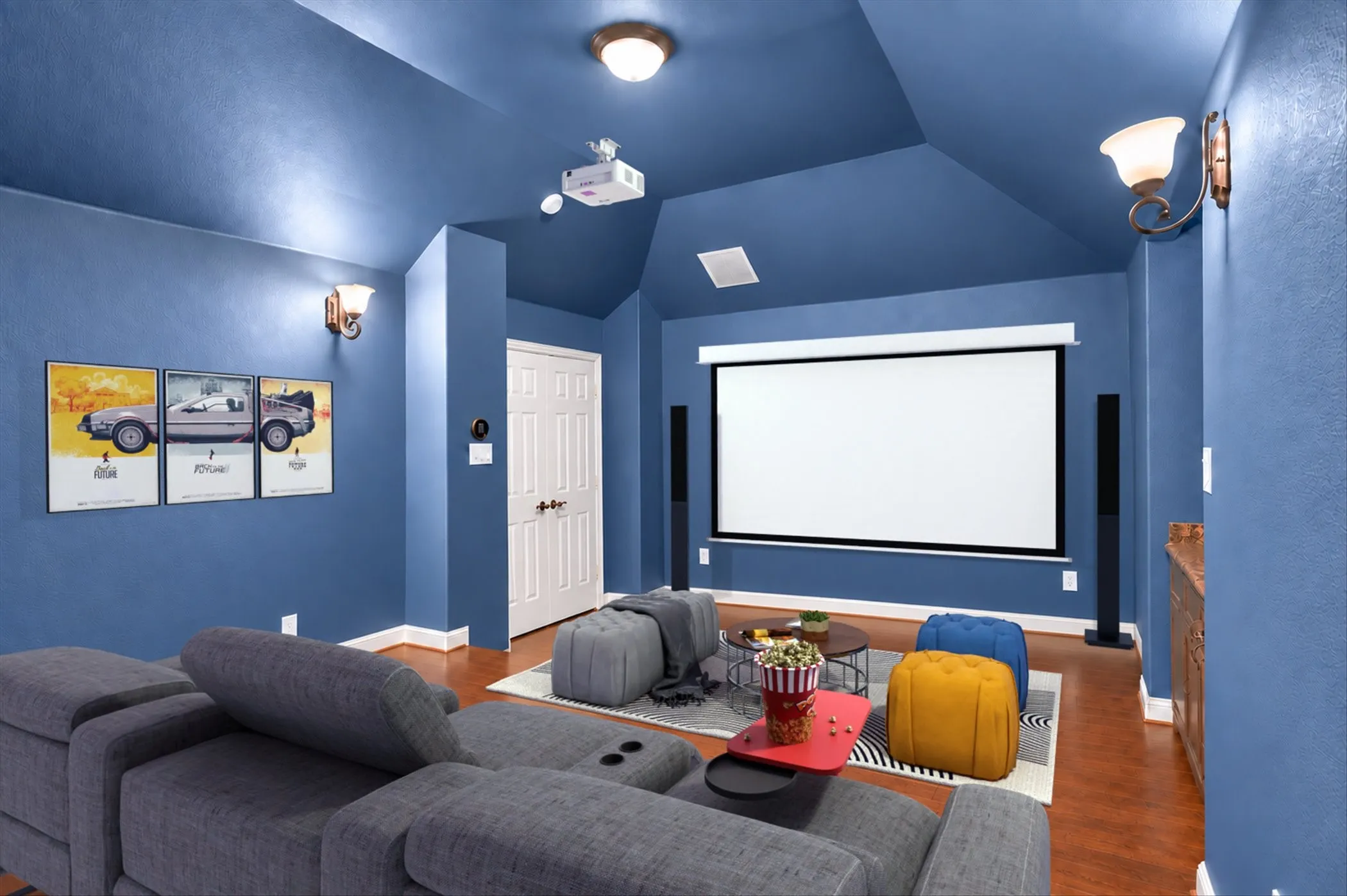 Media room featuring a recessed projector, large projection screen, vaulted ceiling, and hardwood-finish flooring