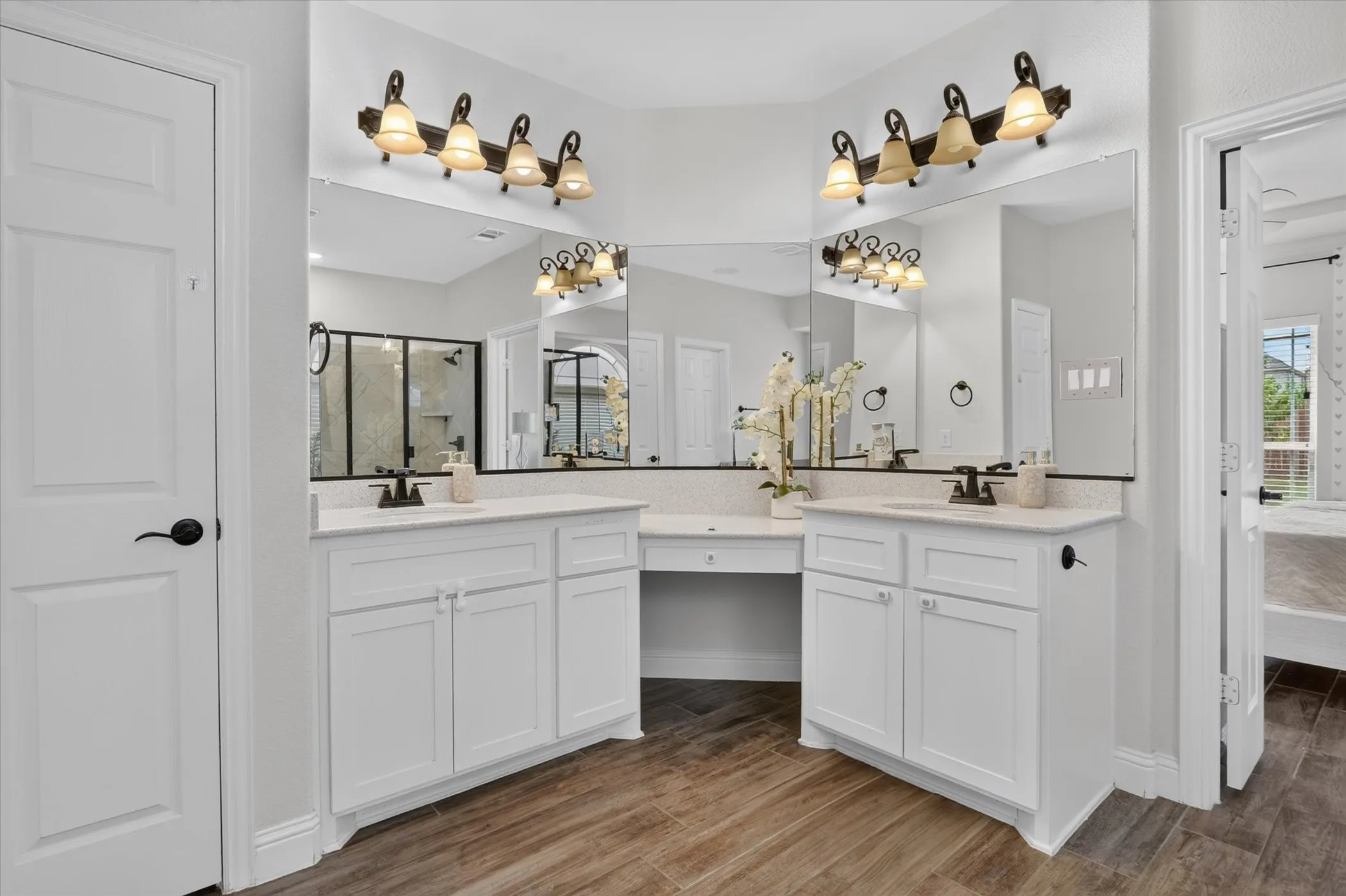 Dual vanities with white cabinetry, integrated sinks, and individual vanity lighting