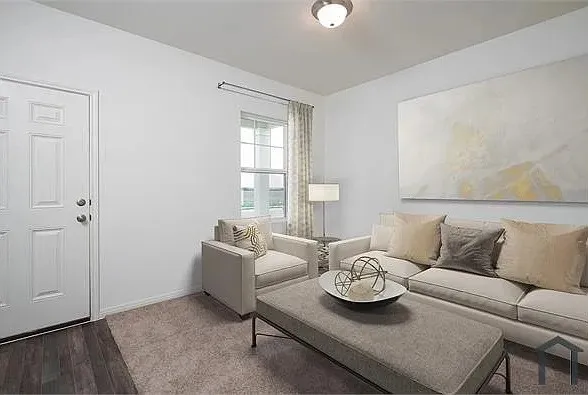 Recessed panel entry door, wood-finish flooring, broad window, flush mount ceiling light, and carpeted floor