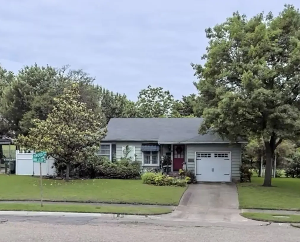Single-story residence with a gray exterior, a red entry door, an attached garage, and a concrete driveway