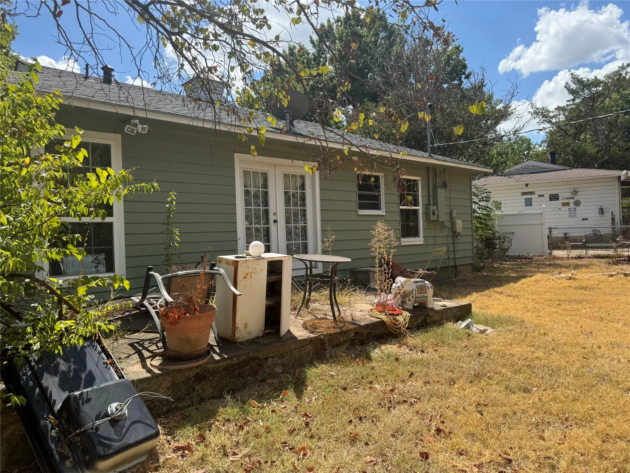 Exterior featuring horizontal siding, white-framed windows, and a patio area with a concrete slab
