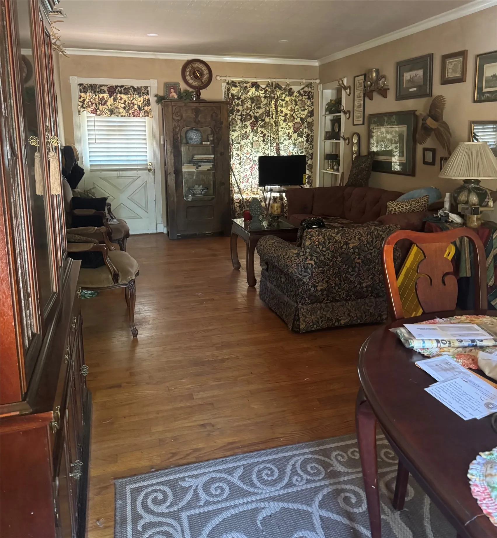 Hardwood flooring, crown molding, and built-in display cabinetry