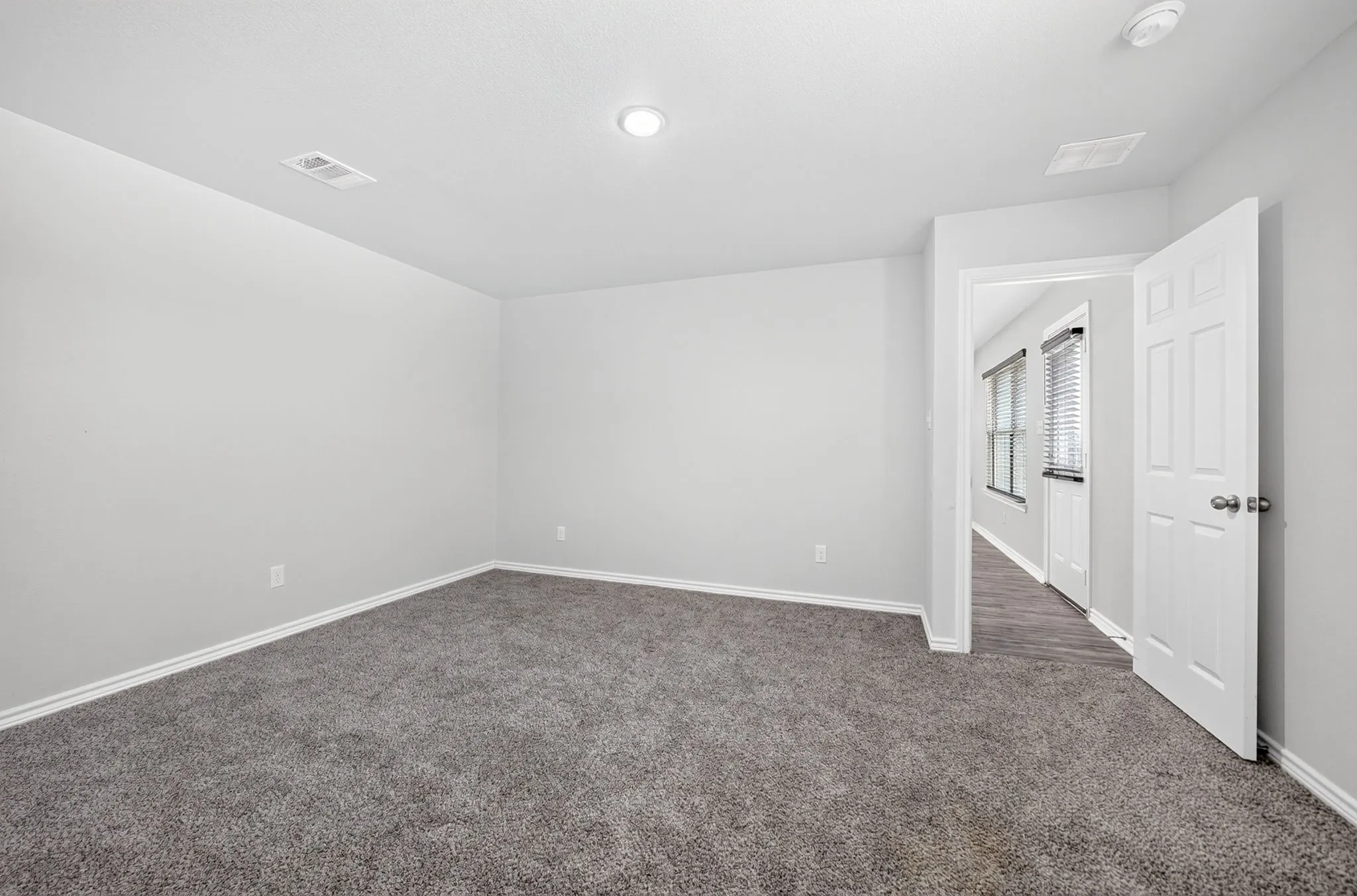 Neutral tone wall finish and gray carpet flooring