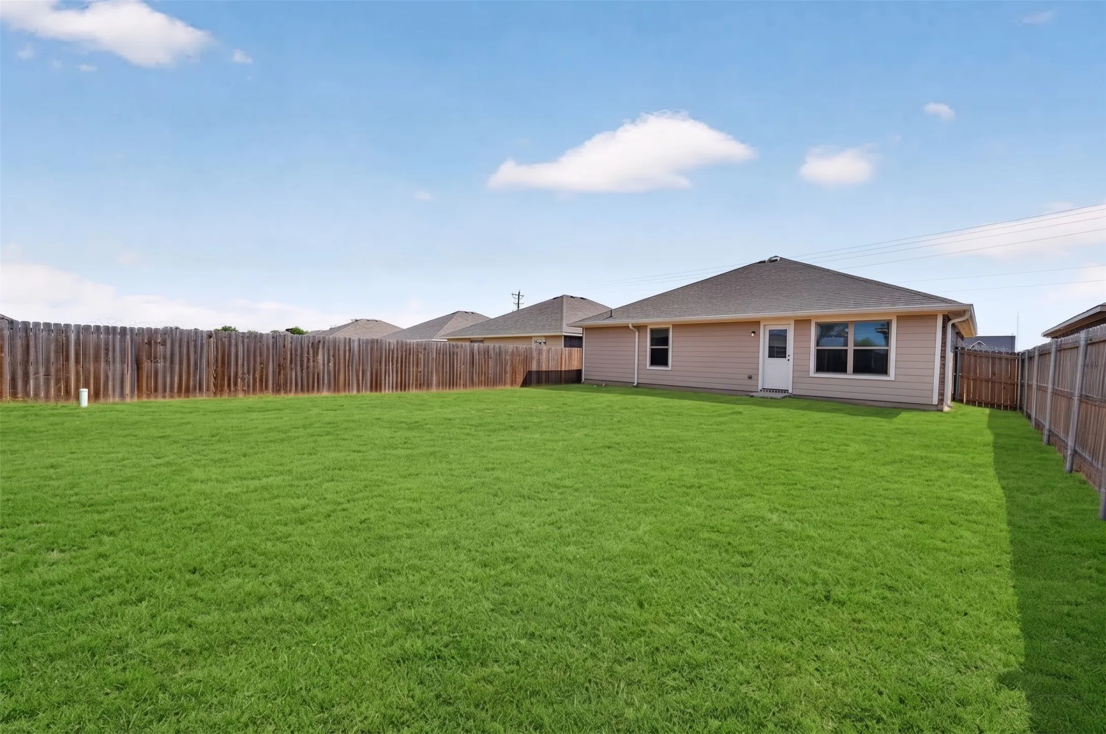 Expansive lawn area with a perimeter wood fence