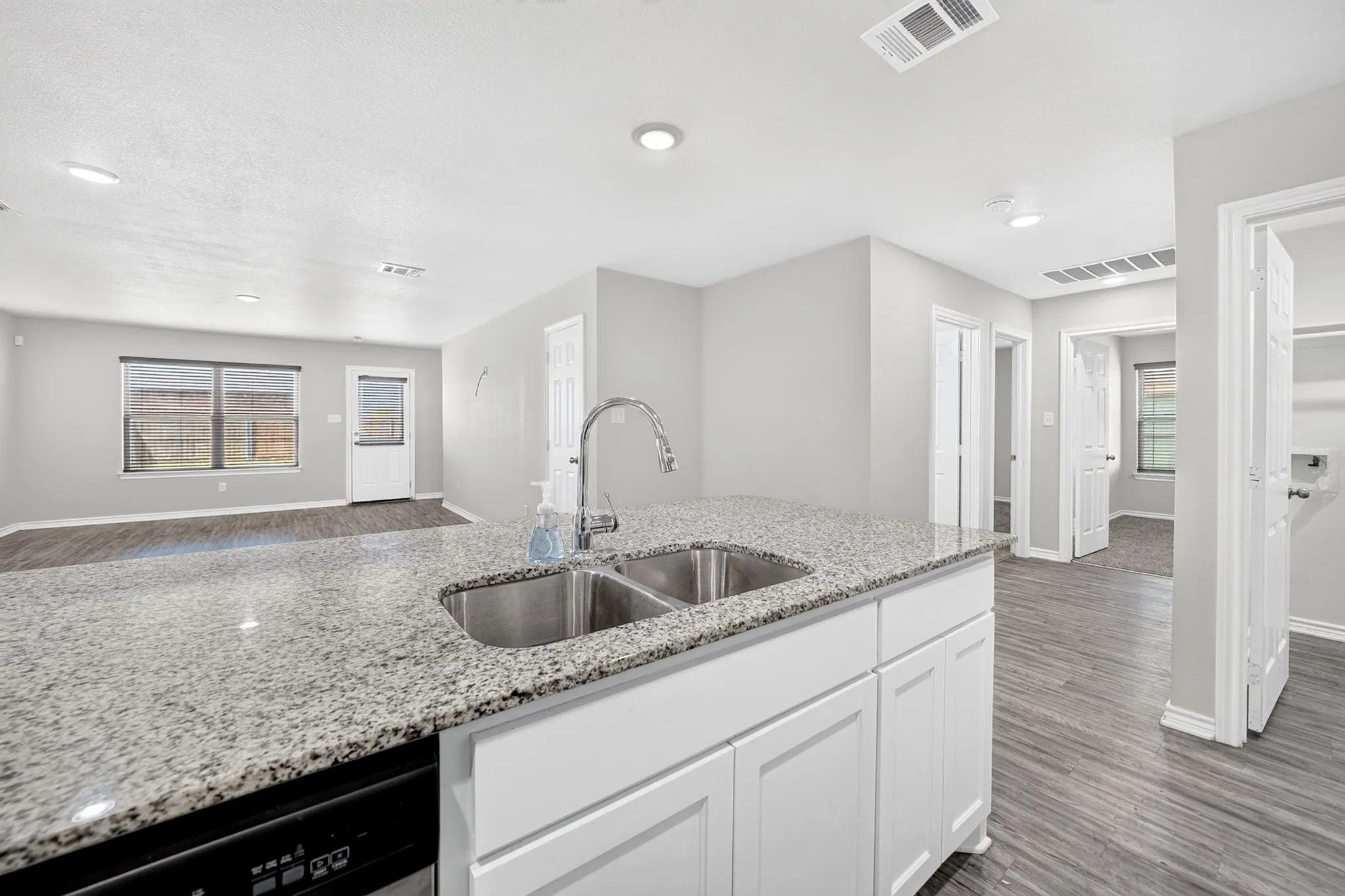 Kitchen island with a double basin stainless steel sink and granite-style countertop