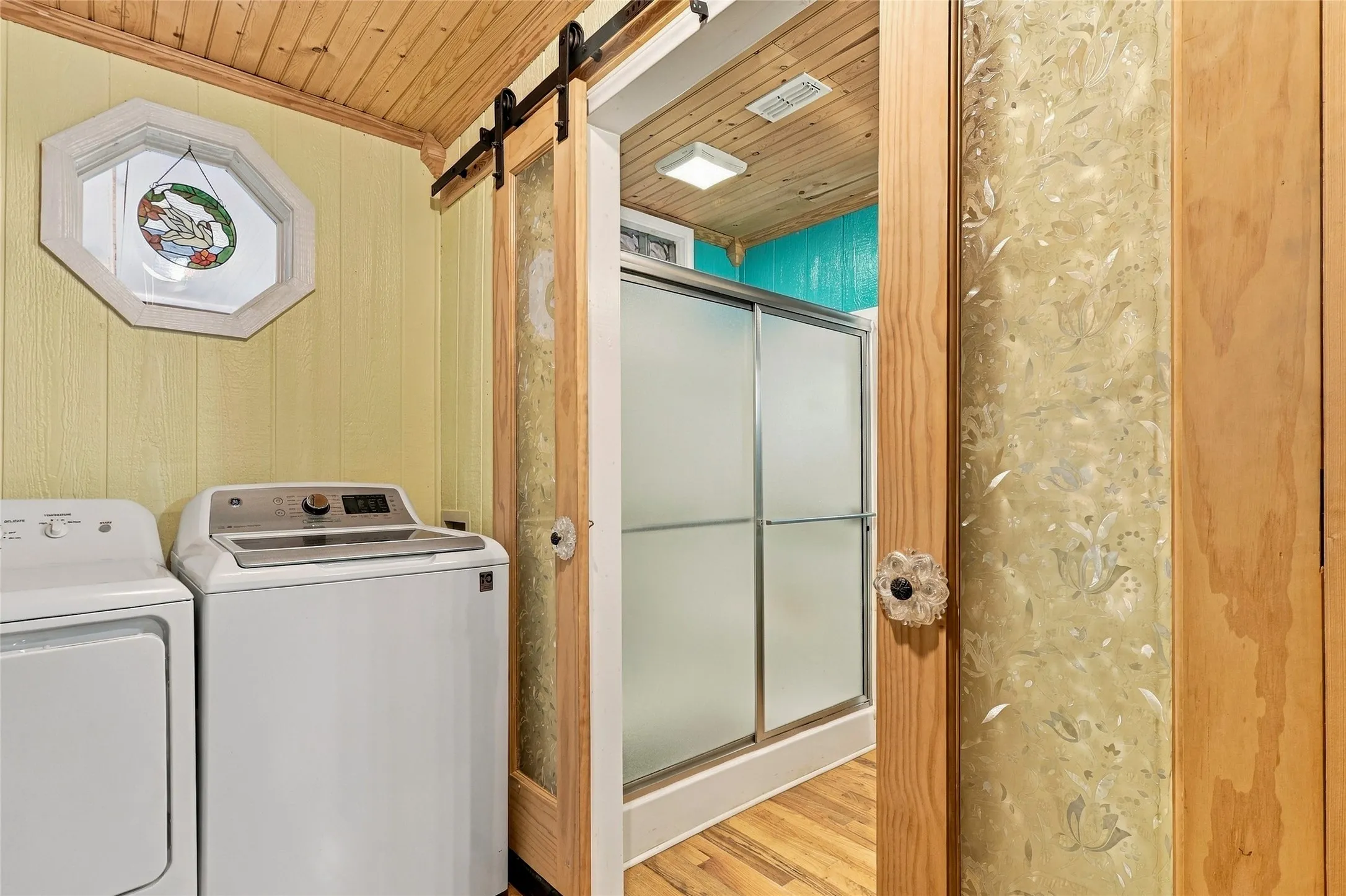 Wood-paneled ceiling with a barn door entry