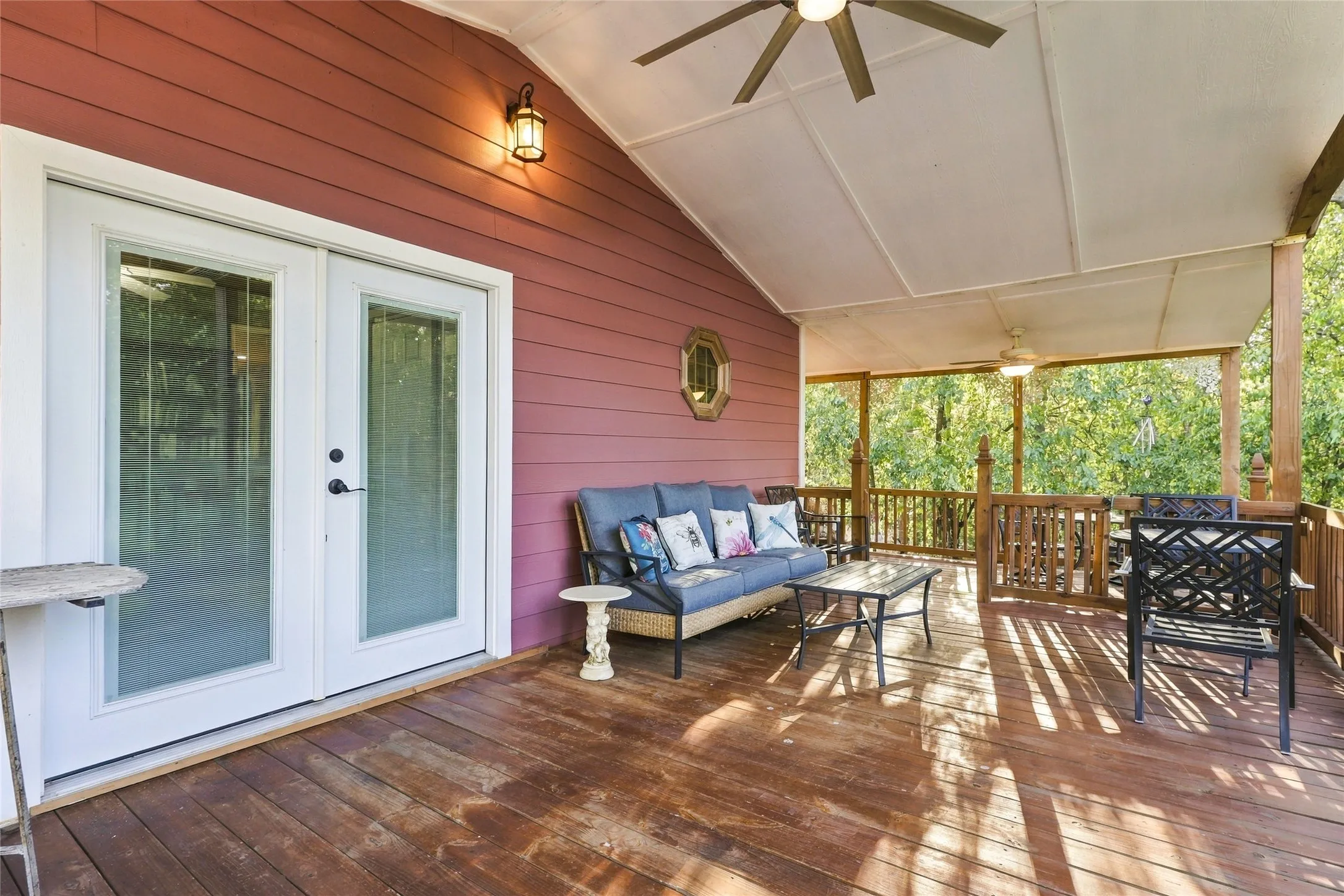 Expansive wood-finish deck with a vaulted ceiling, wood railing, and dual ceiling fans