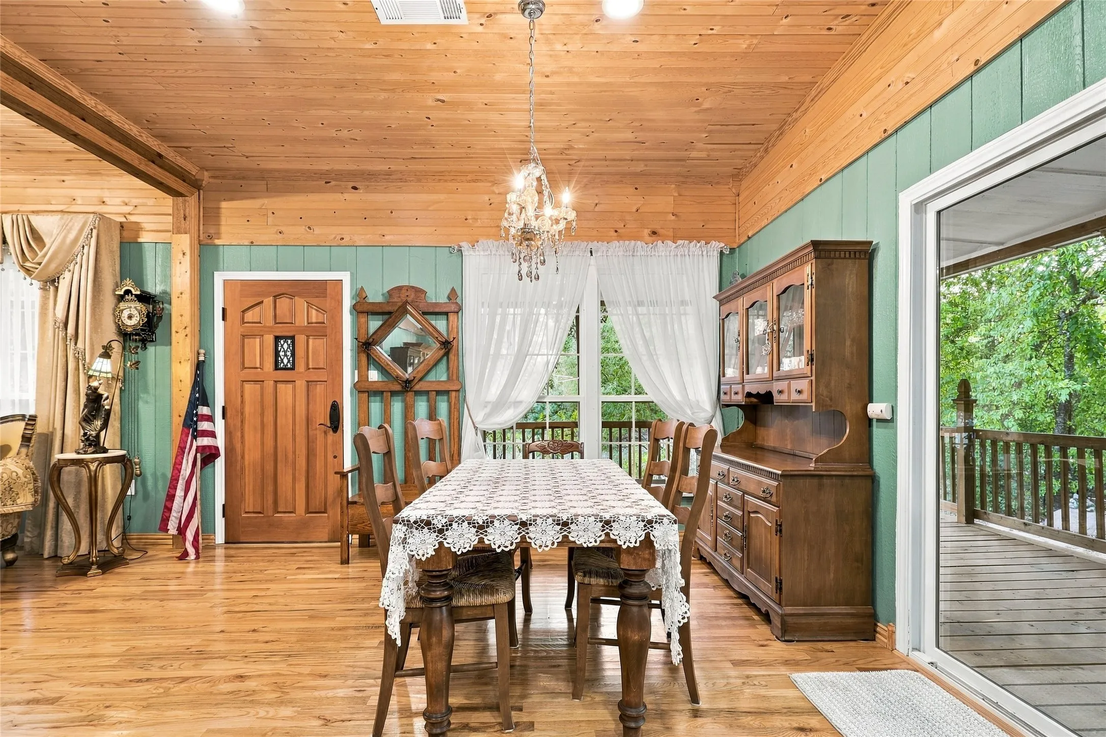 Wood-finish flooring, wood-paneled ceiling, wood-paneled walls, and a glass-paned exterior door