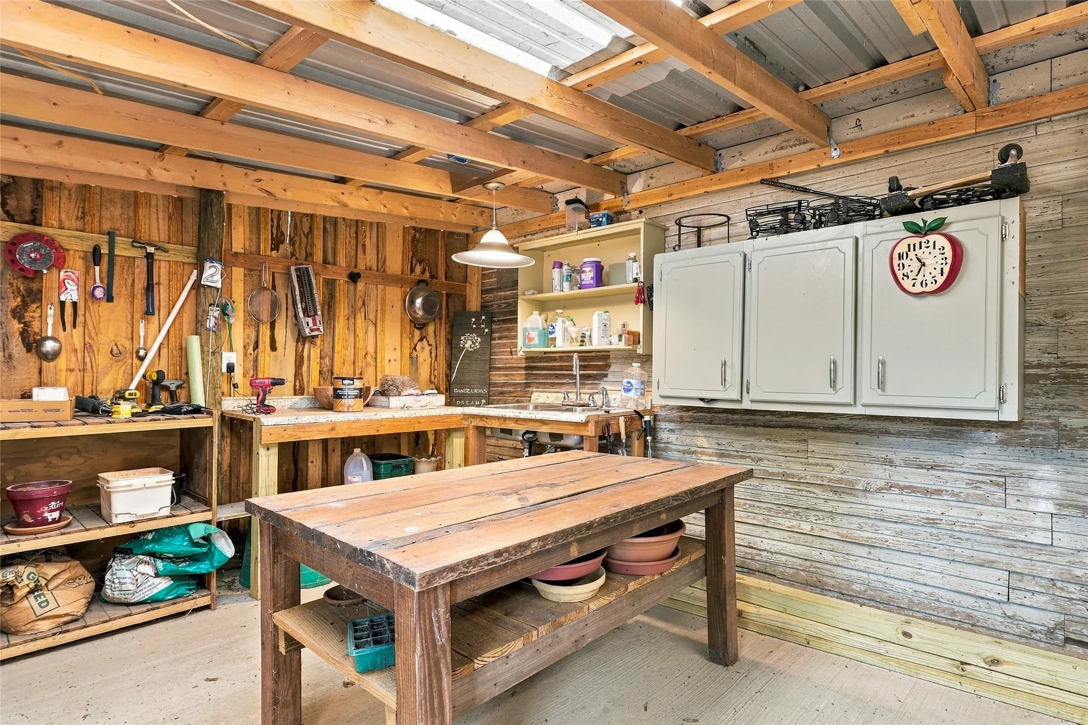 Exposed wood beam ceiling, wood plank wall paneling, built-in shelving, work surfaces, and wall-mounted cabinetry