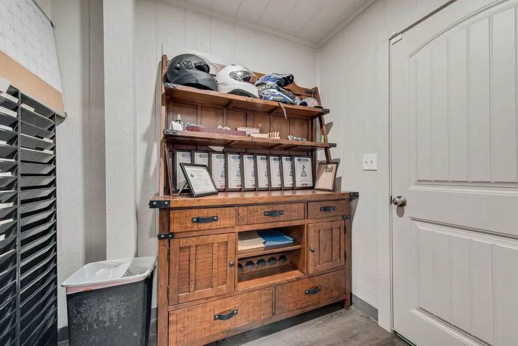 Wood hutch with storage, white paneled walls, and a white interior door