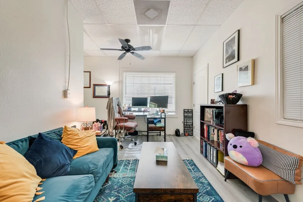 Wood-finish flooring, ceiling fan, and window with blinds