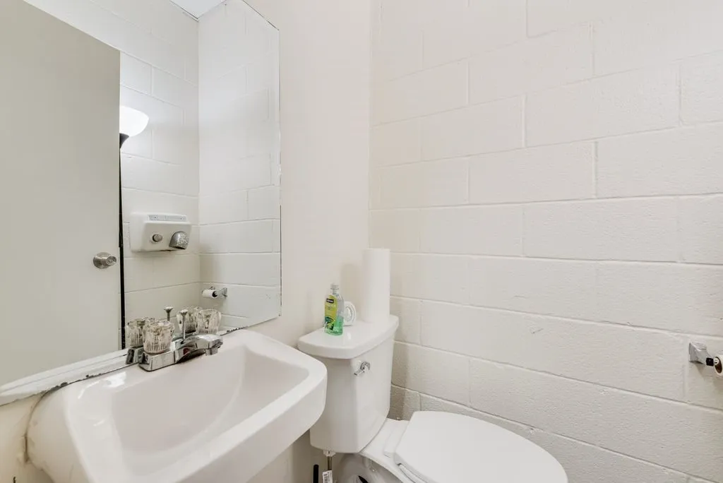 White ceramic wall-mounted sink with chrome faucet