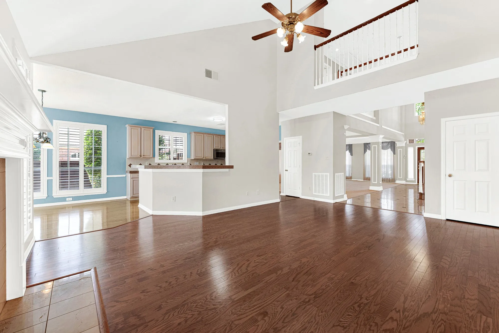 An overhead indoor balcony overlooks the main floor, creating an airy connection between the levels while wide sightlines lead directly into the kitchen. It’s easy to envision chatting with family while prepping dinner as kids play nearby